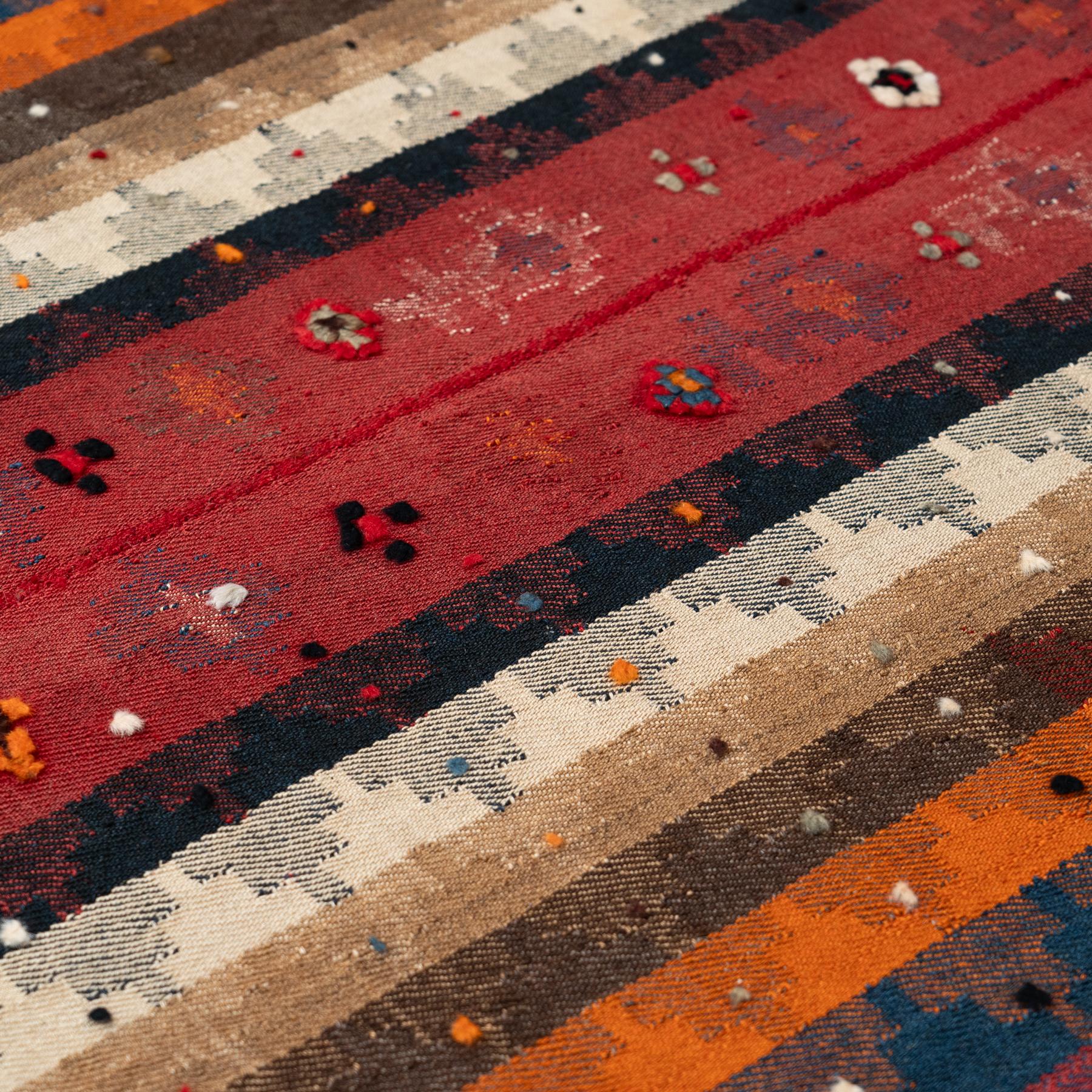 Cet exquis tapis Kilim marocain vintage, tissé à la main vers 1980, présente un étonnant motif géométrique et rationaliste dans des tons rouges riches et chauds. Mesurant 155 x 231 cm, ce Kilim est d'une taille parfaite pour ajouter un style