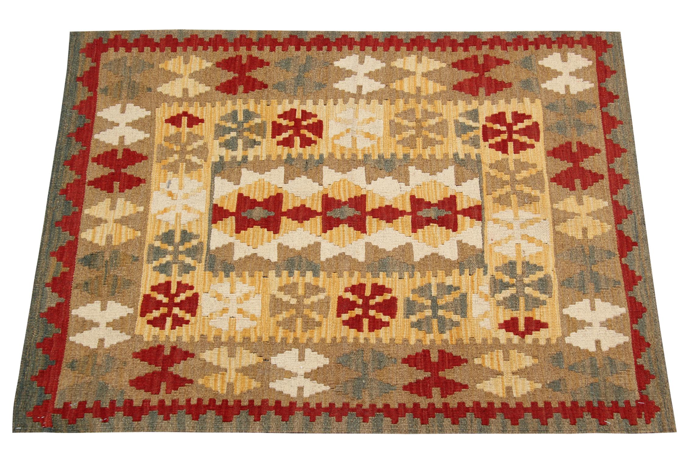 This elegant wool rug was woven by hand in the early 2000s in Afghanistan. The central design has been woven with a geometric, symmetrical pattern woven in accents of beige, red and green. Featuring tribal motifs throughout both the centre and