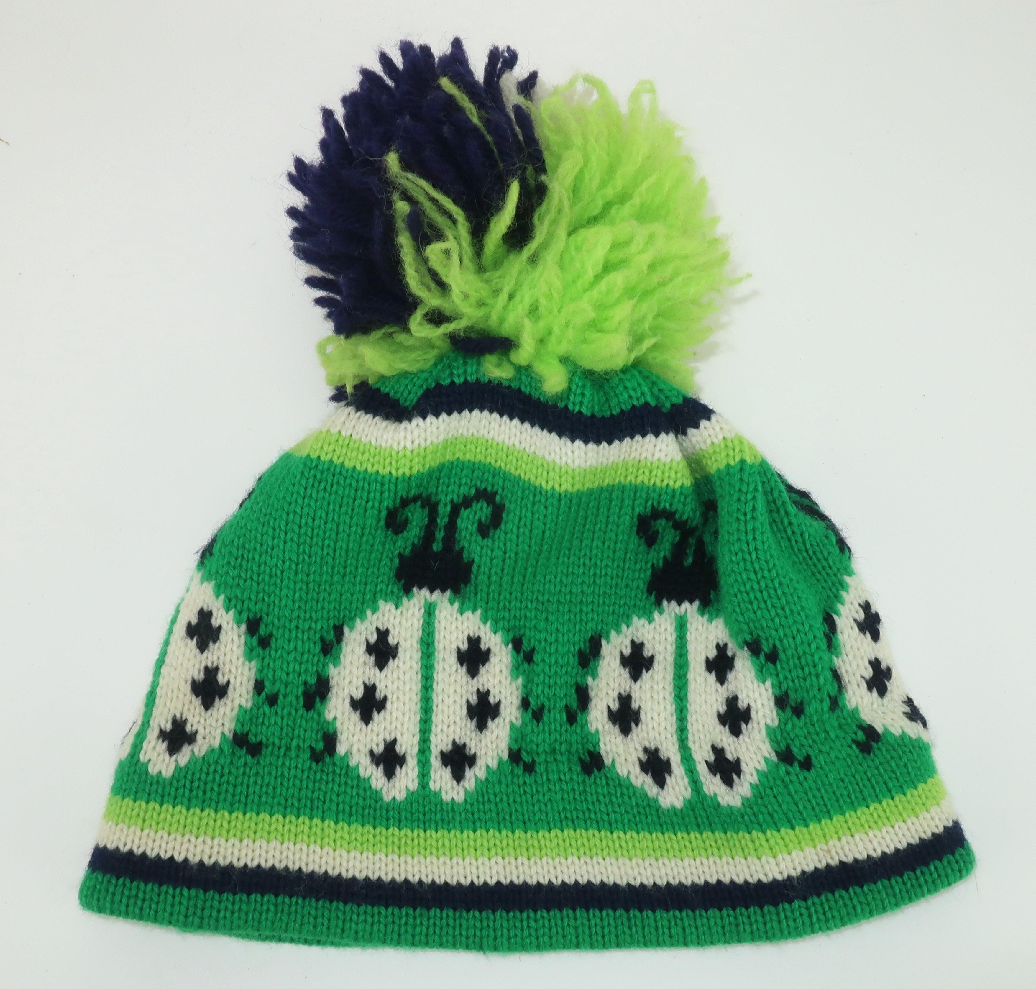 Hit the slopes with a vintage Aris wool ski hat complete with adorable ladybug motif and pom pom finial.  It is a colorful combination of kelly green and spring green with black and winter white accents.  The pom pom is tricolor with a fluffy life