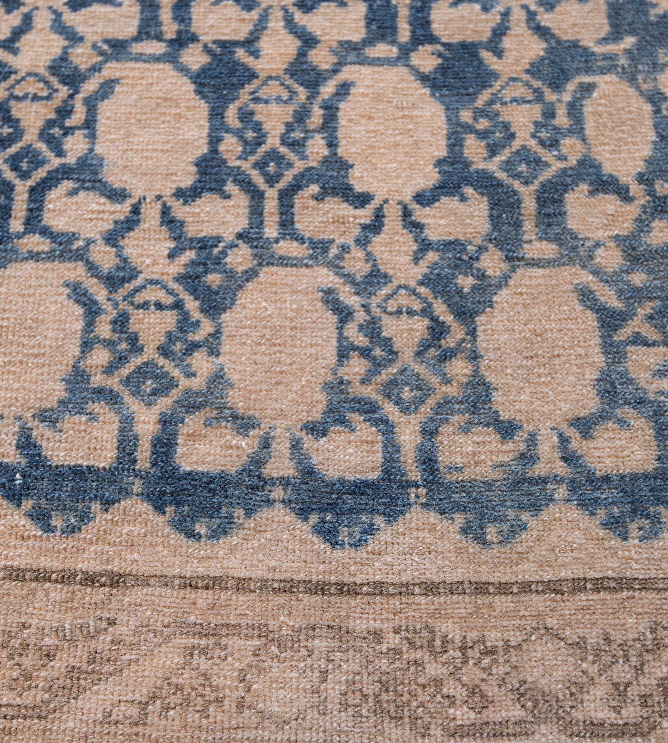 This Malayer rug has a deep indigo-blue field with an overall design of linked buff-brown angular vine linking floral boteh, in a buff-brown border of angular fox-brown meandering serrated leaf vine issuing flowerheads between minor fox-brown