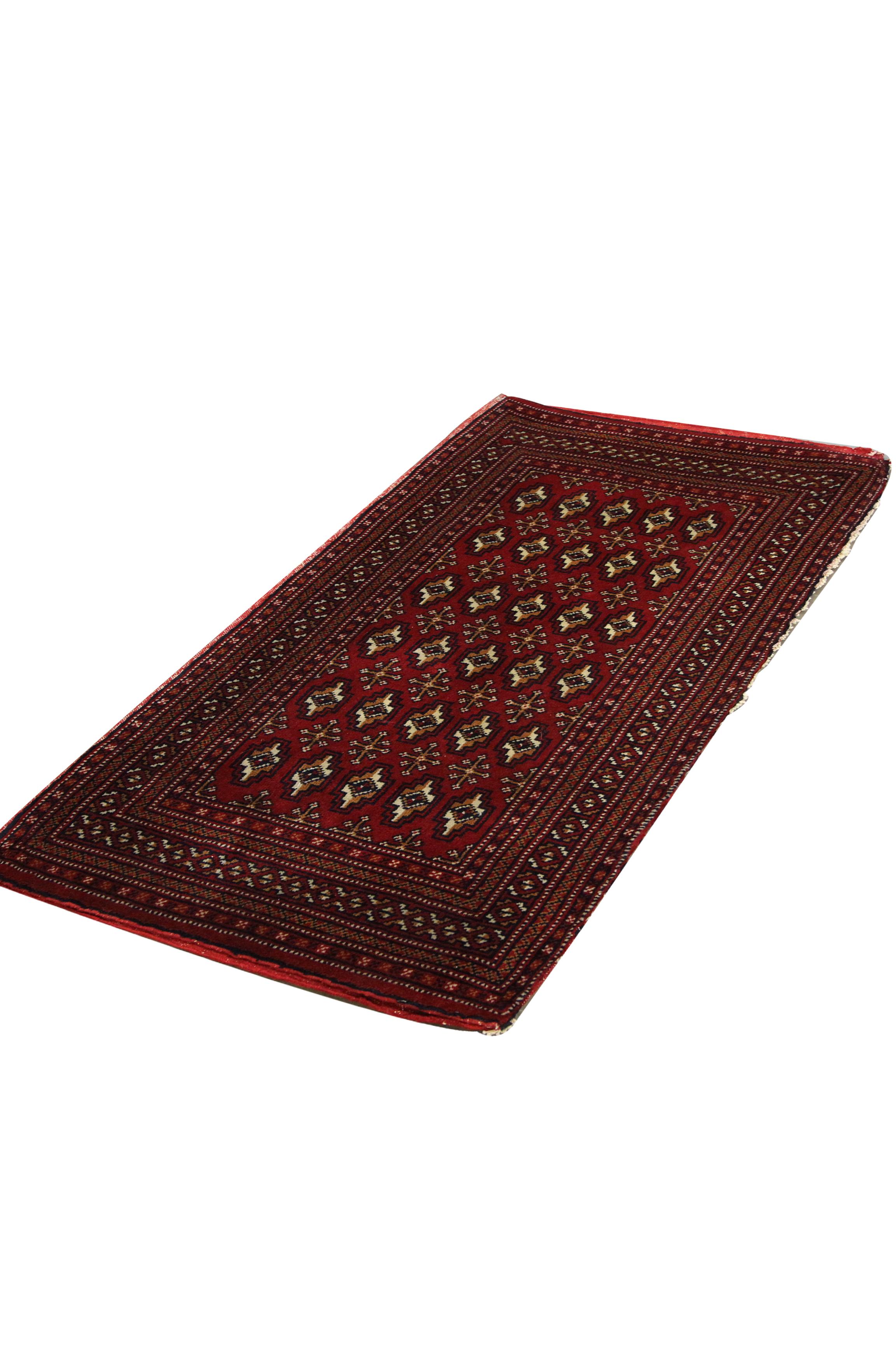 This vintage carpet is a great example of handwoven rugs constructed in the 1960s. The central design features a traditional repeating pattern design woven on a rich red background with accents of brown, cream and beige. The traditional design and