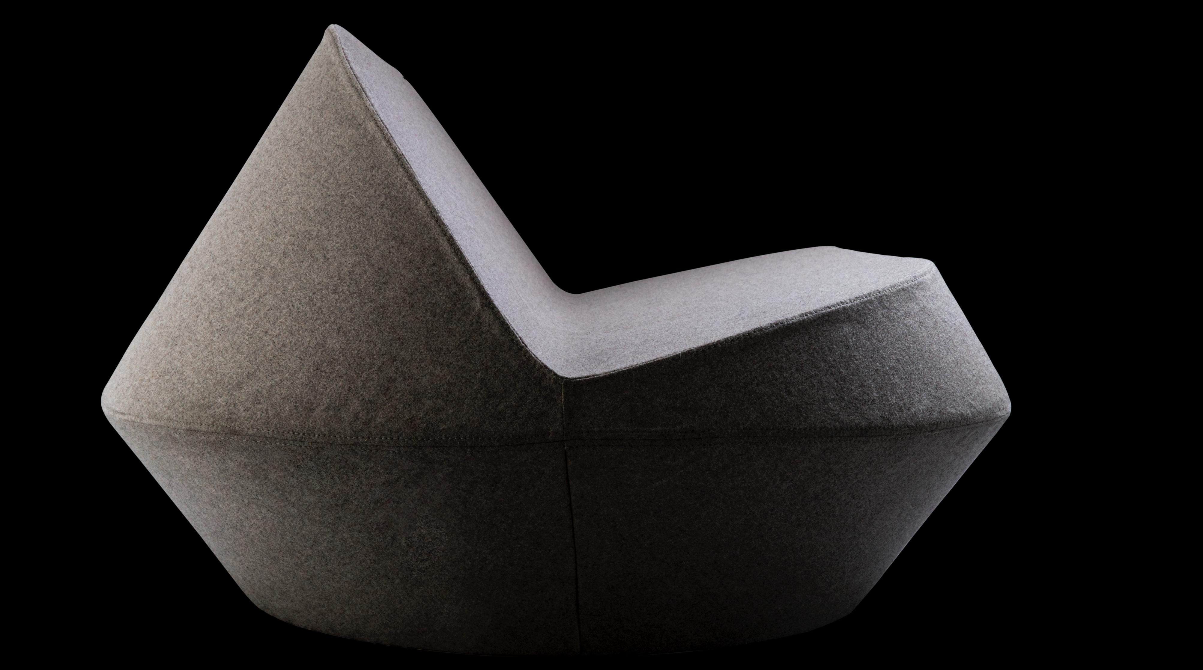 A wool loveseat design that is both contemporary and timeless, with geometrical cuts that fit to small spaces complimenting both residential and corporate interiors. The foam brings softness and structure at the same time making the piece flexible,
