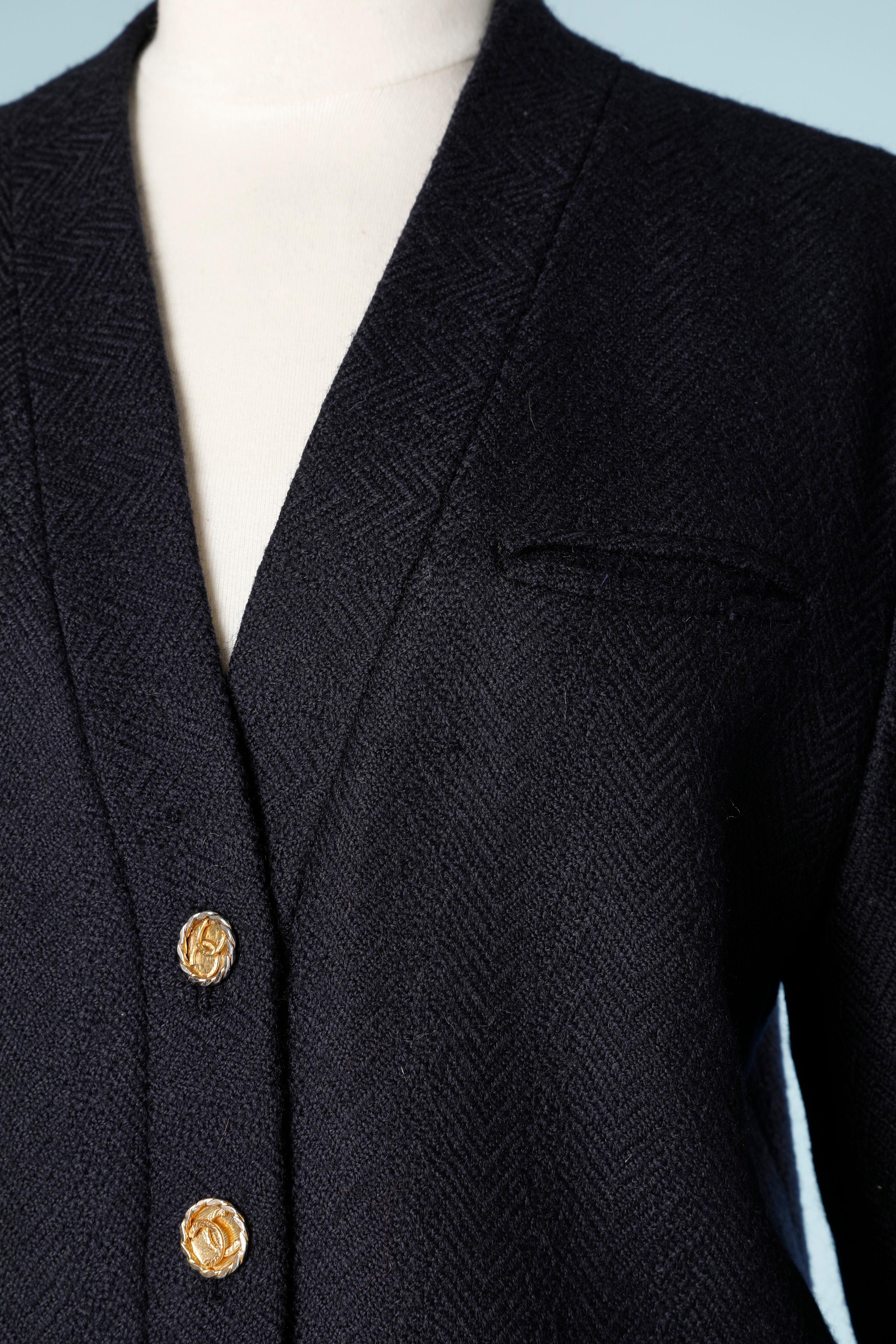 Costume jupe en laine bleu marine avec boutons de marque. Motif chevron ton sur ton 
TAILLE : 38 Fr ( Jupe 36 Fr) 