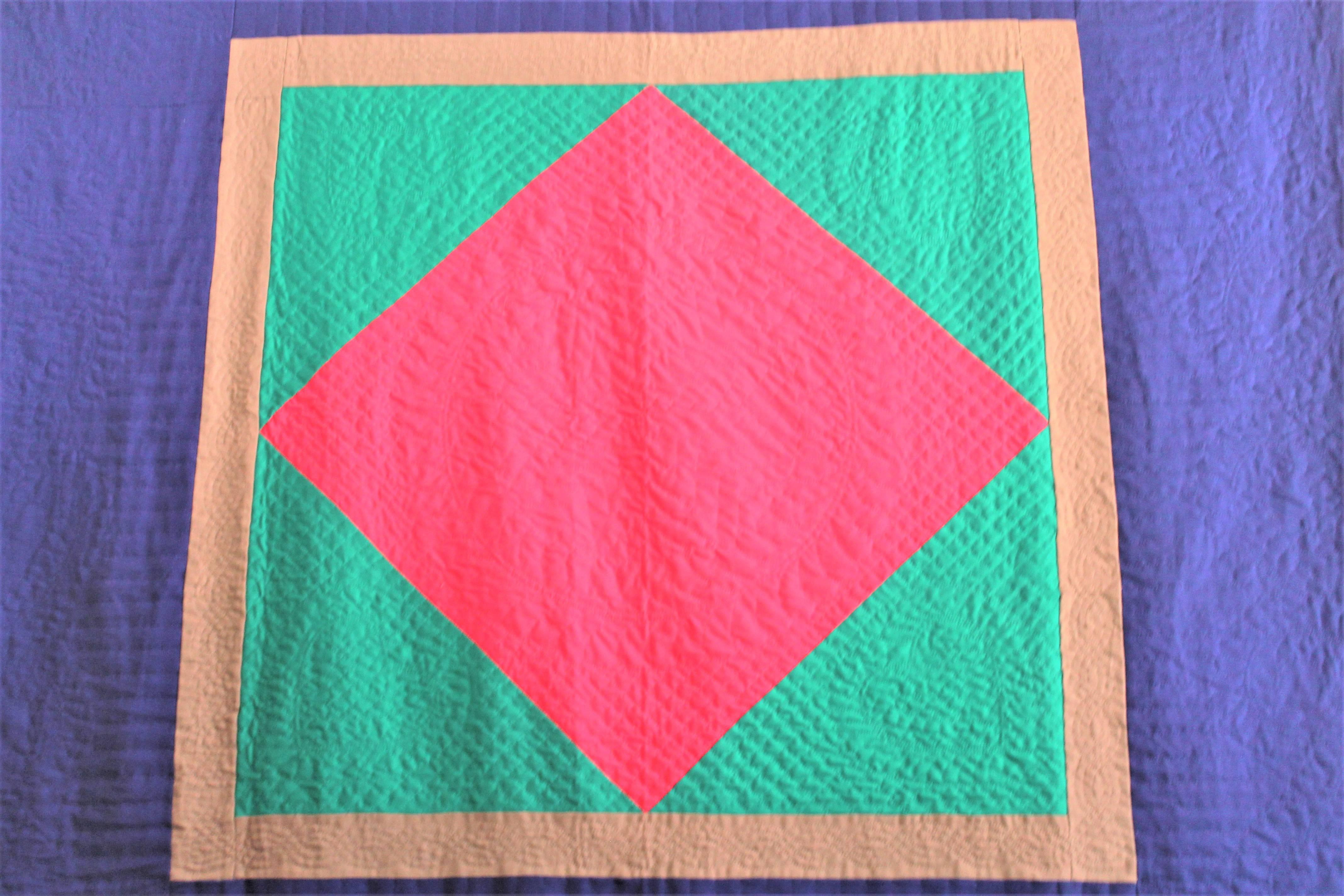 This amazing all wool floating diamond in a square quilt is in fine condition and unusual colors. The centre diamond is in a cherry red with a large royal blue border. The quilting and piece work is the very best. This is a late but great quilt that