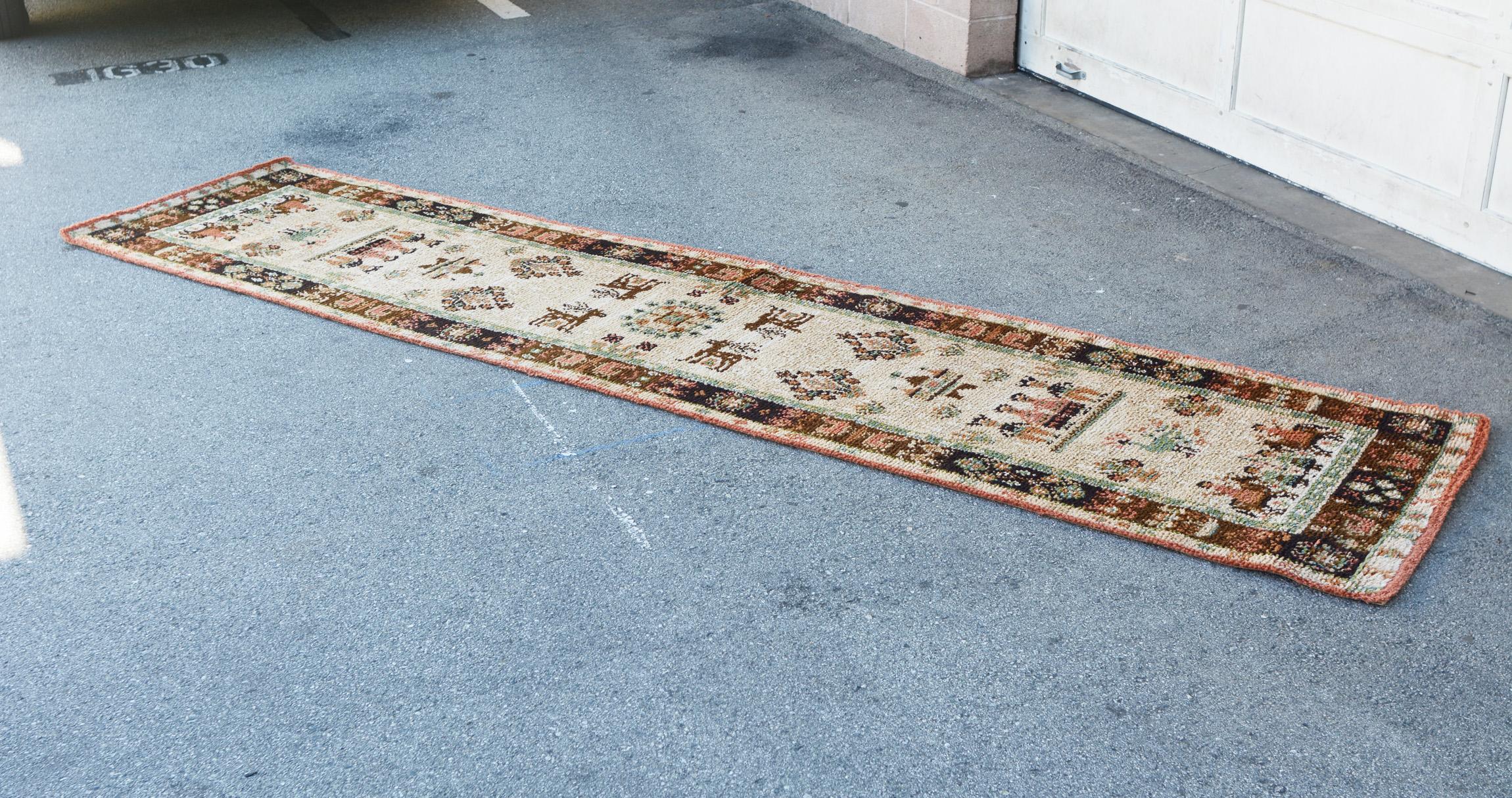 Eleven and half foot long 100% wool runner by Ege Axminster. This is part of the Ege Country series and titled Mountain Life. This whimsical rug depicts elements of traditional life in Denmark's mountains. The pile is a half inch thick. There are no