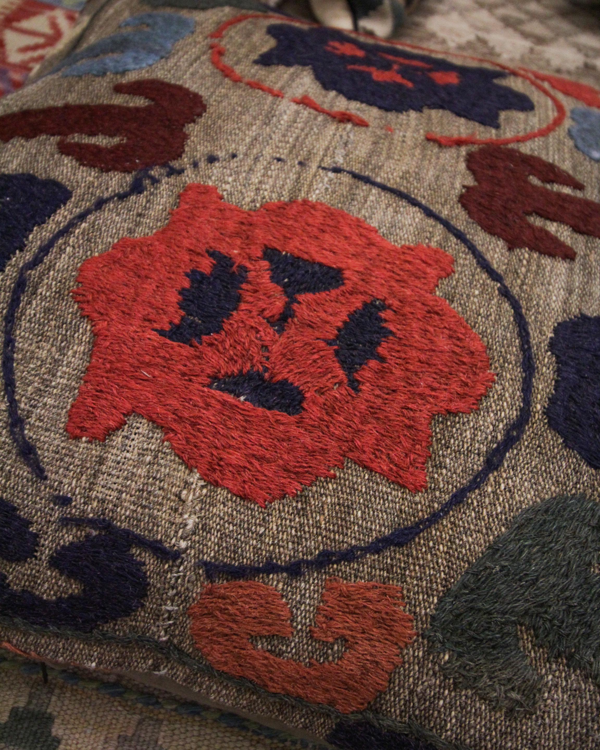Cette housse de coussin tribale unique est une pièce plus grande adaptée à un lit ou un canapé. Tissé avec un motif tribal unique et répétitif aux accents de brun, rouge, beige, orange et vert sur un fond beige-brun. La palette de couleurs et le