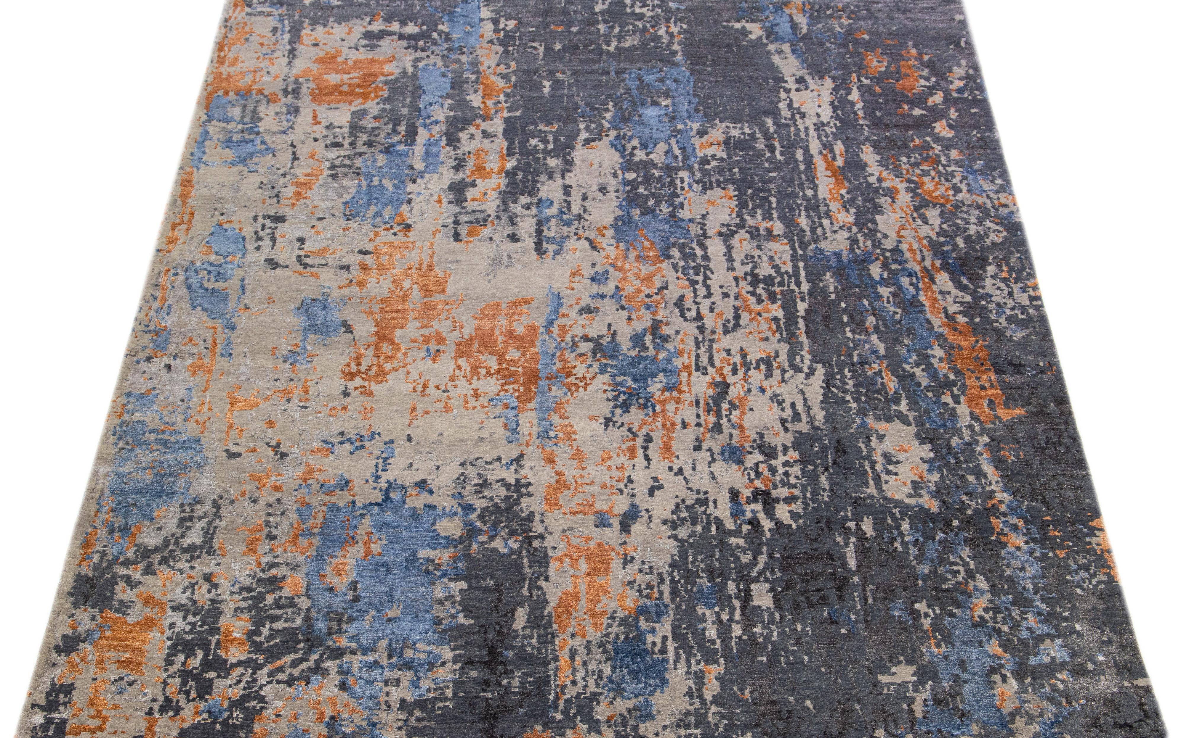 This Indian wool and silk blend rug features a tan field with an abstract pattern detailing gray and orange colors. Its composed materials provide robustness and longevity, while its ornamental design infuses any room with sophistication.

This
