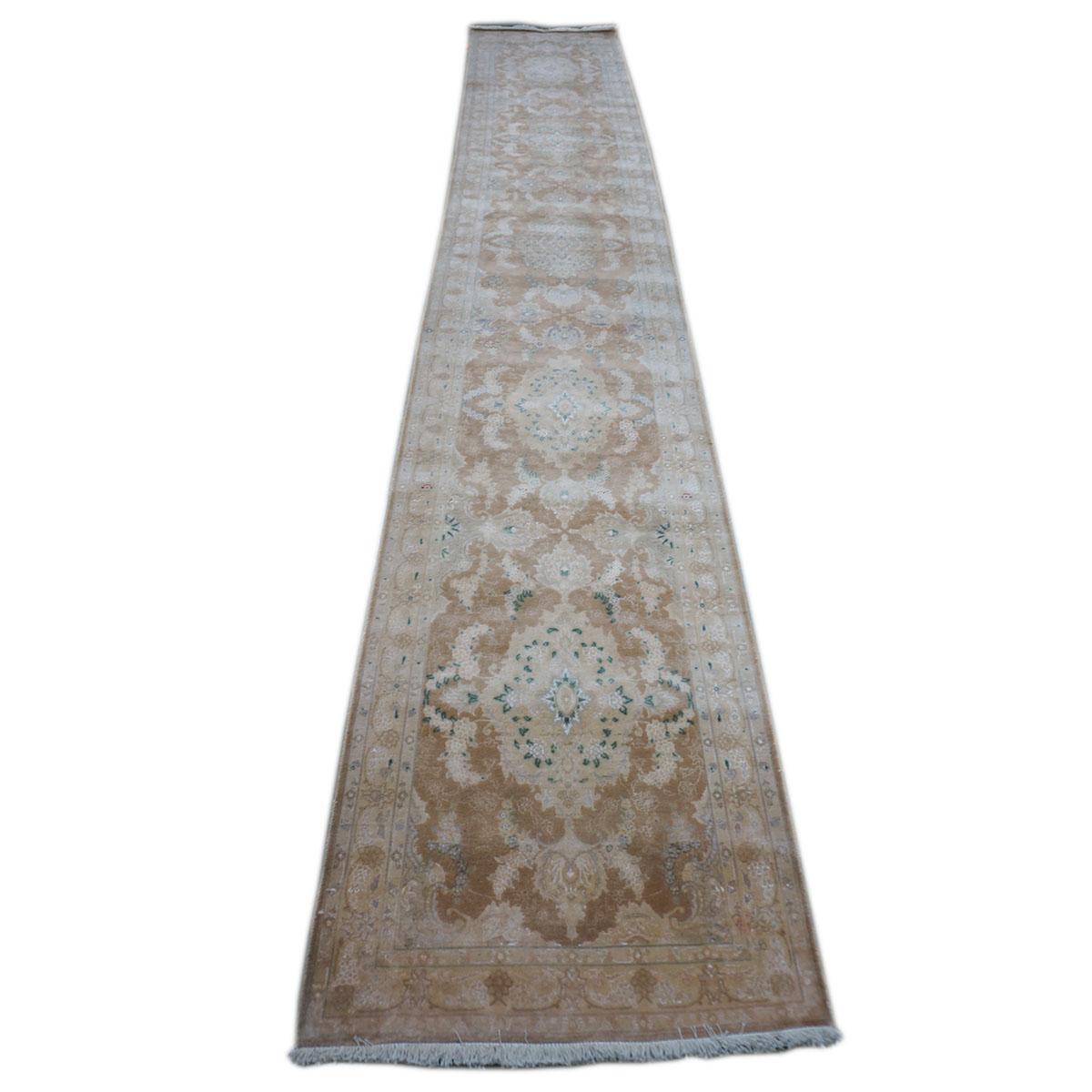 Ashly Fine Rugs presents a Vintage Persian Tabriz Hall Runner Rug. Tabriz is a northern city in modern-day Iran and has forever been famous for the fineness and craftsmanship of its handmade rugs. This beautiful runner has a light brown and ivory