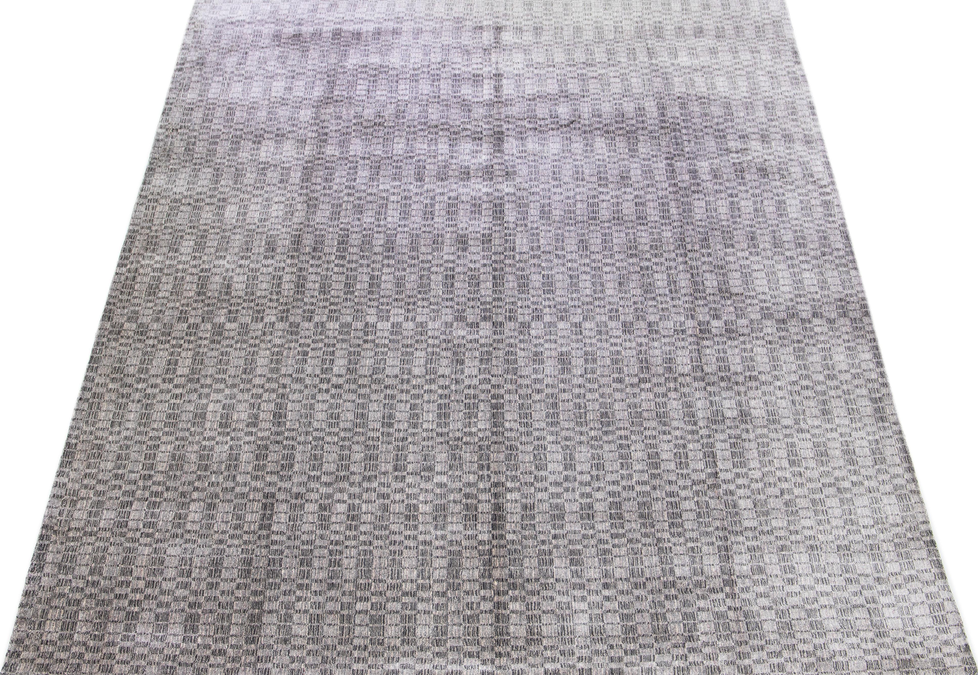 This exquisite contemporary wool and silk rug showcases a striking gray-silver base adorned with a stunning geometric pattern that gracefully flows from end to end.

This rug measures 10' x 14'.

Our rugs are professional cleaning before