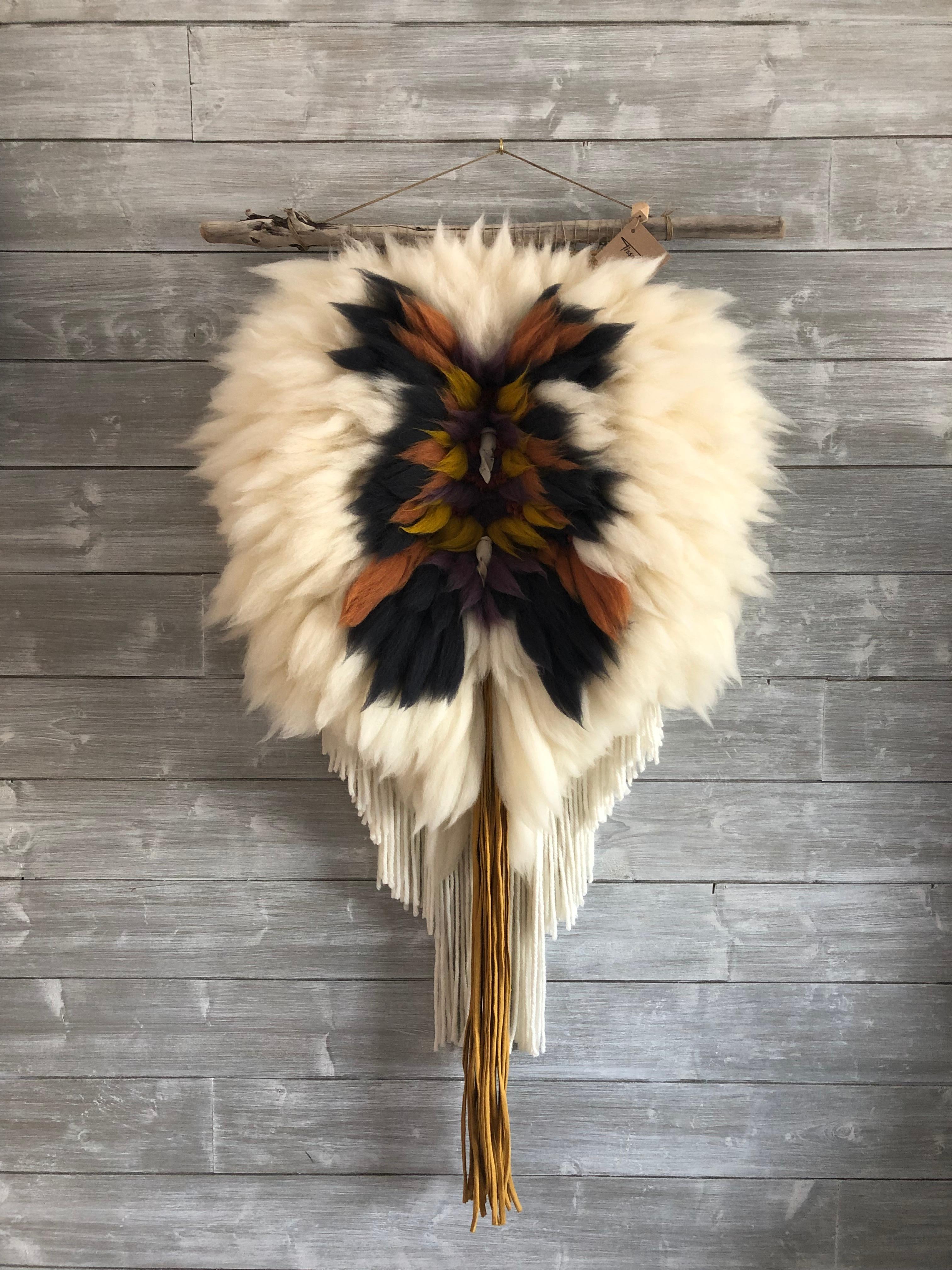 Handsome handcrafted wall hanging is an explosion of autumn colors made of carded wool and wool yarn (alpaca & merino). It features ceramic pearls and dangling fringe of recycled cotton. The piece is suspended from a branch of drift wood for elegant