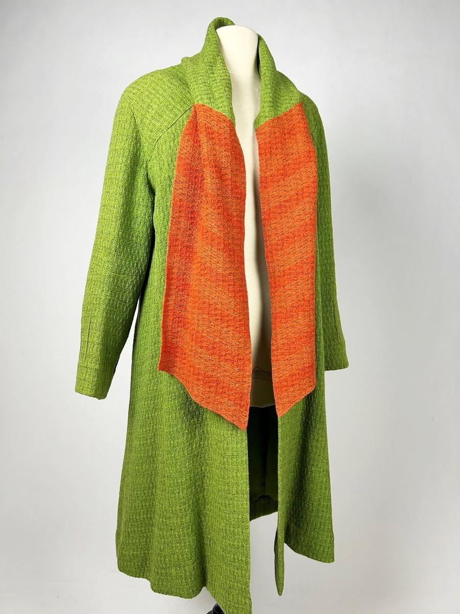 Summer 1934 Collection

France

Haute Couture afternoon coat by Jeanne Lanvin in absinthe green mottled wool knit underlined by an orange scarf, integrated into the neckline. Straight cut, long sleeves, fastened with a press stud in front. Fine
