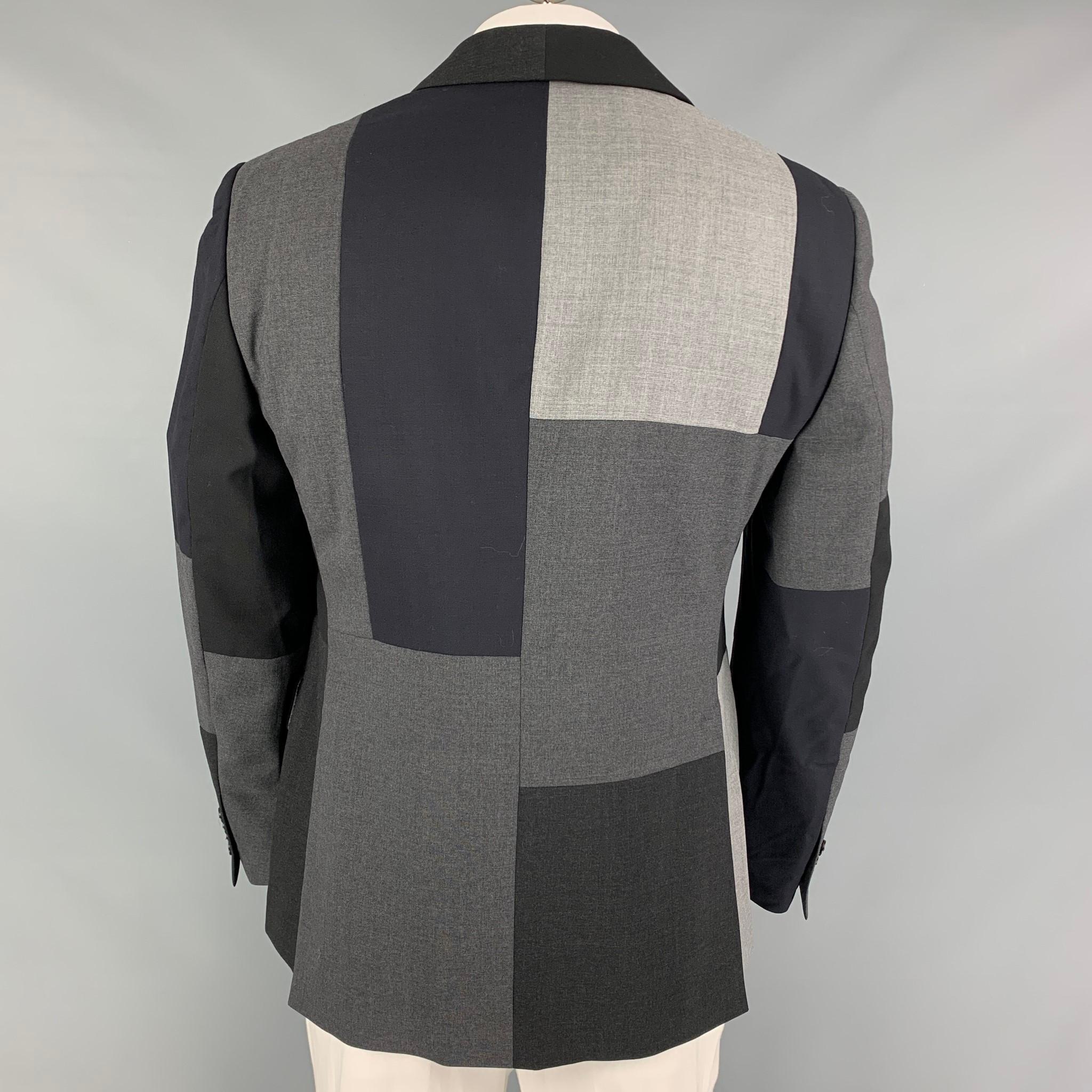 WOOSTER + LARDINI sport coat comes in a navy & grey patchwork  with a full liner featuring a notch lapel, flap pockets, double back vent, and a three button closure. Made in Italy. 

Excellent Pre-Owned Condition.
Marked: