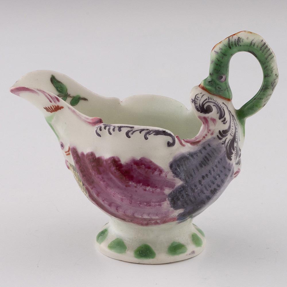 Überschrift : Worcester Dolphin Ewer Creamboat
Datum : 1765-68
Zeitraum : Georg III.
Markierungen : Keine
Herkunft: Worcester, England
Farbe : Ploychrom
Merkmale: Neunauge Griff. Die hochreliefierten Muscheln sind in Rot und Grau gehalten, die