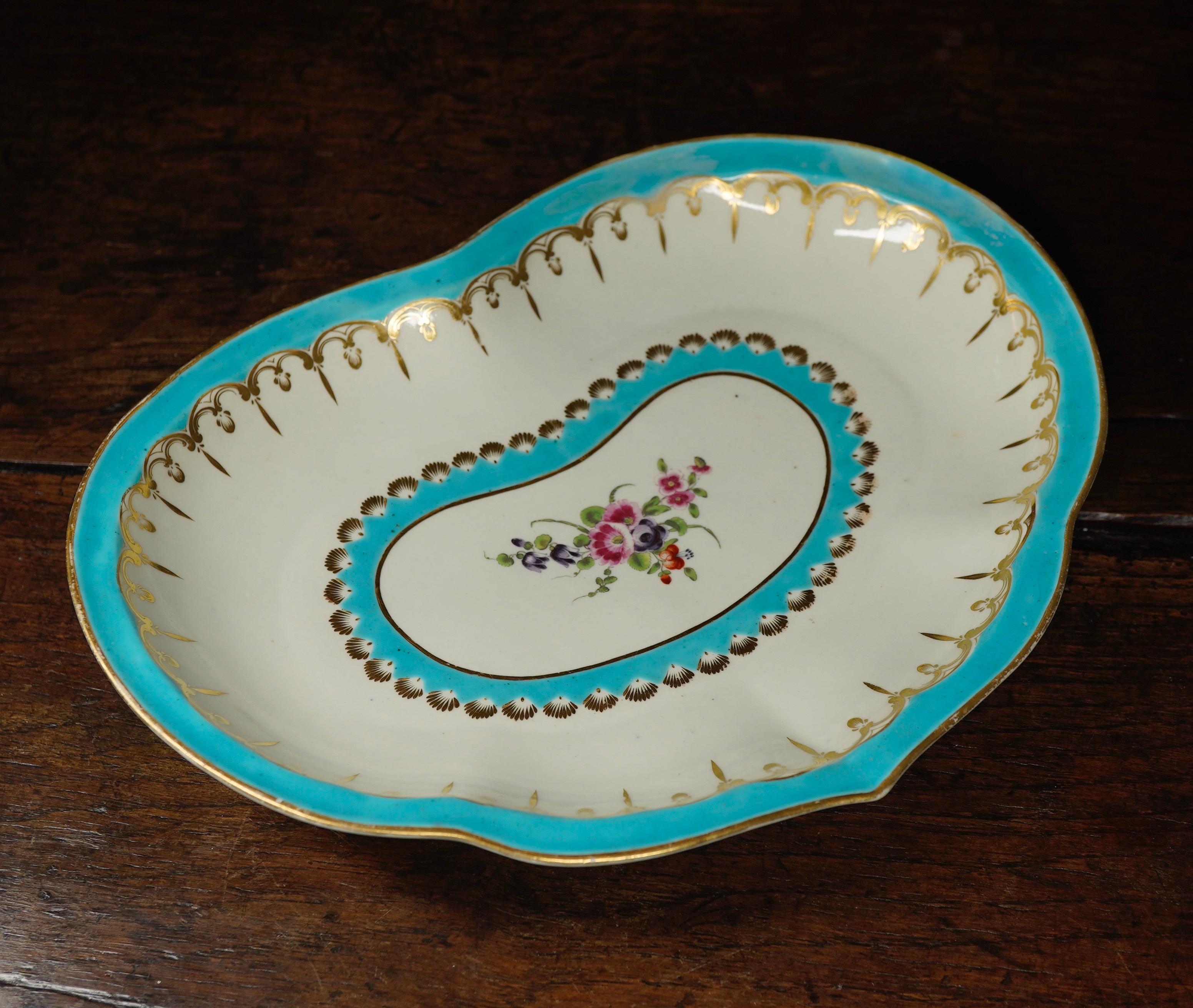 Dr Wall Worcester serving dish of heart shape, decorated with two bands of ‘sky blue’ borders with gilt scallops and pendants, around a central colourful flower group.
Unmarked,
circa 1770.