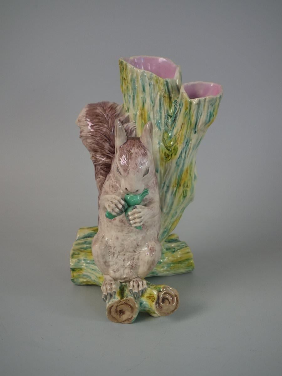 Royal Worcester Majolica vase which features a squirrel sitting at the base of a tree trunk, nibbling a chestnut. Coloration: brown, pink, ochre, are predominant. The piece bears maker's marks for the Royal Worcester pottery. English diamond