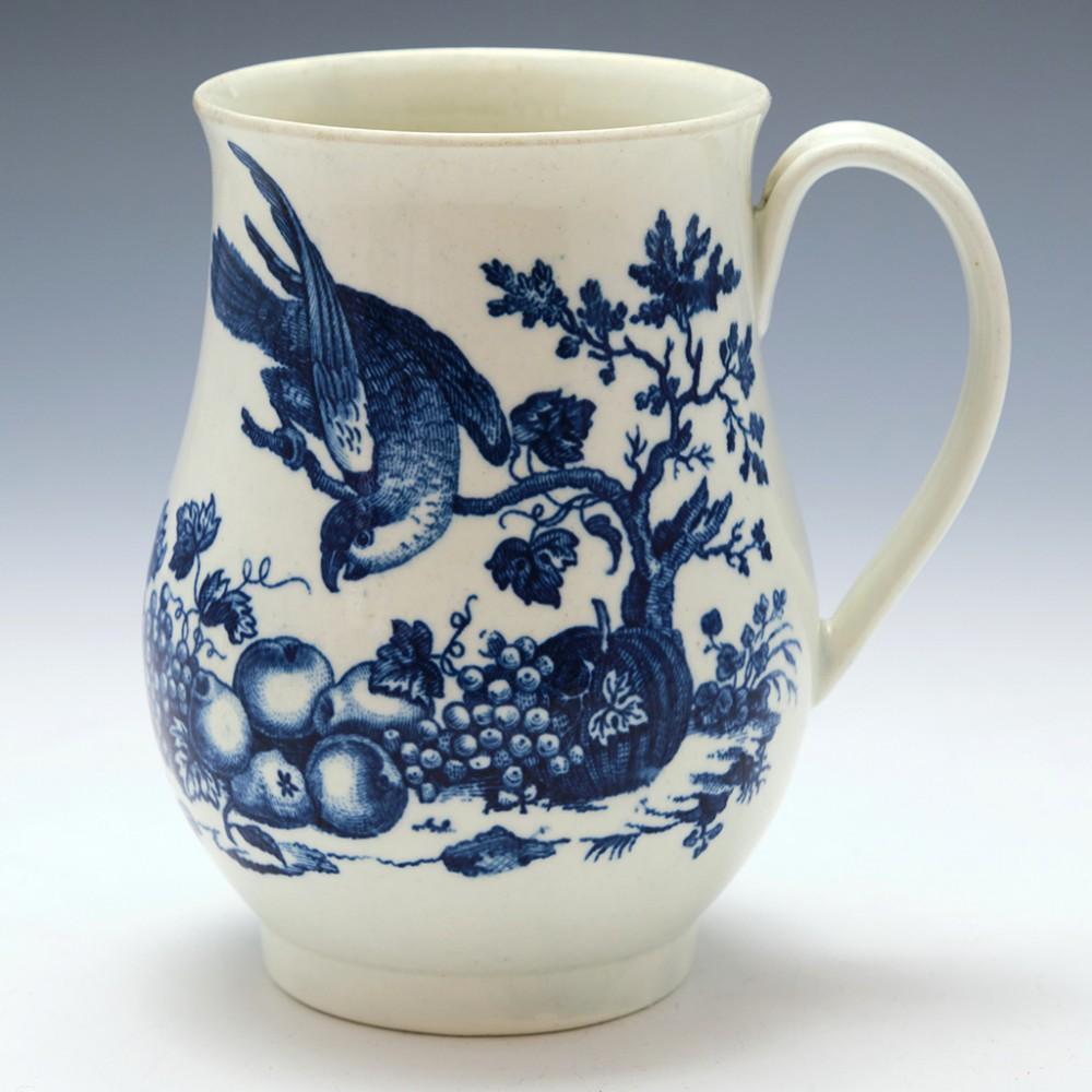 Heading :  A Worcester Porcelain Cider Mug of baluster form
Date : 1770-1785
Period : George 111
Marks : Elaborate script W mark
Origin : Worcester
Colour : Blue and White
Pattern :The Parrot Pecking Fruit pattern /Second Version 
Features : Strap