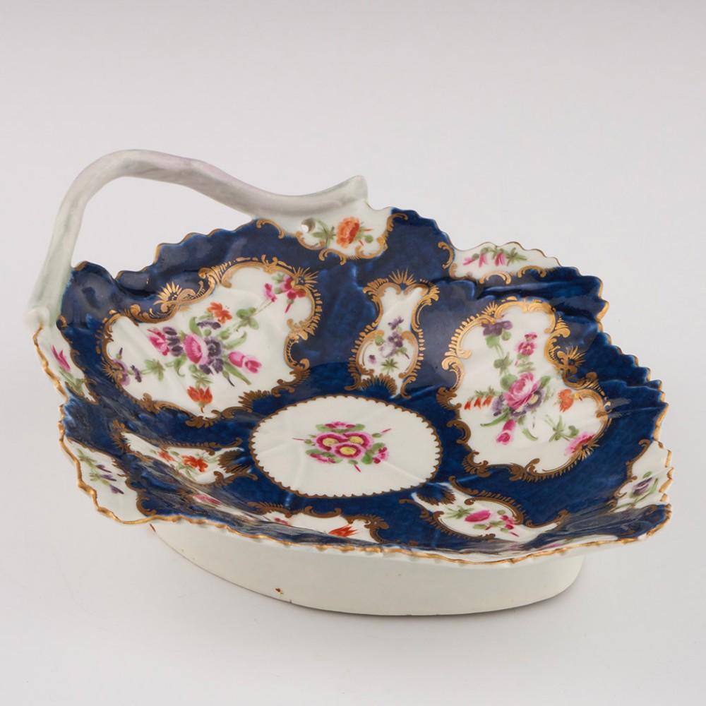 Heading :  Worcester porcelain blue scale leaf dish
Date : c1775
Period : George III
Marks : Pseudo fret square
Origin : Worcester, England
Colour : Polychrome
Pattern : Blue scale mirror and vase with floral sprays

Features: Gilded