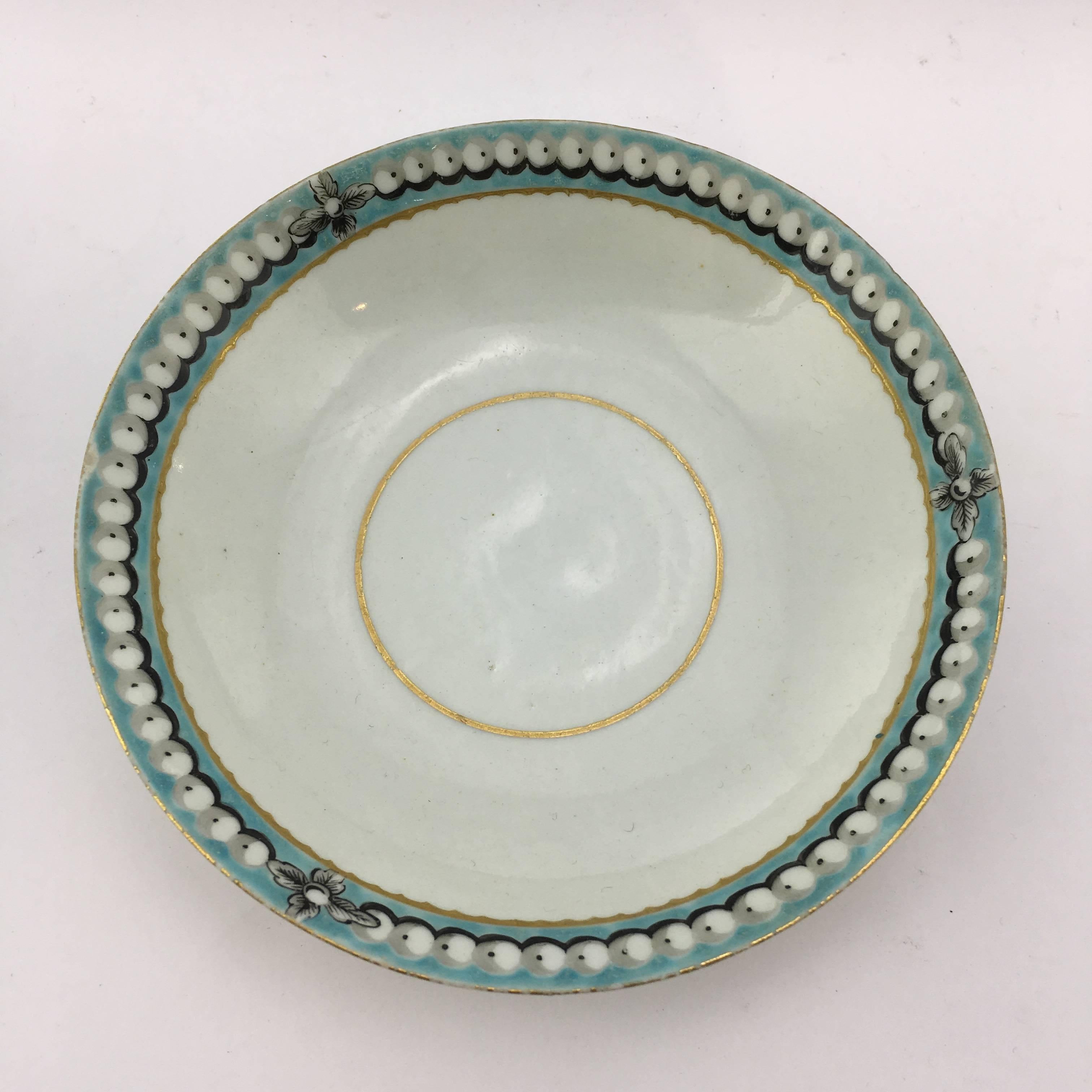 Worcester tea bowl and saucer, decorated in an elegant pattern with turquoise border with pearls, within gold line borders, circa 1770.