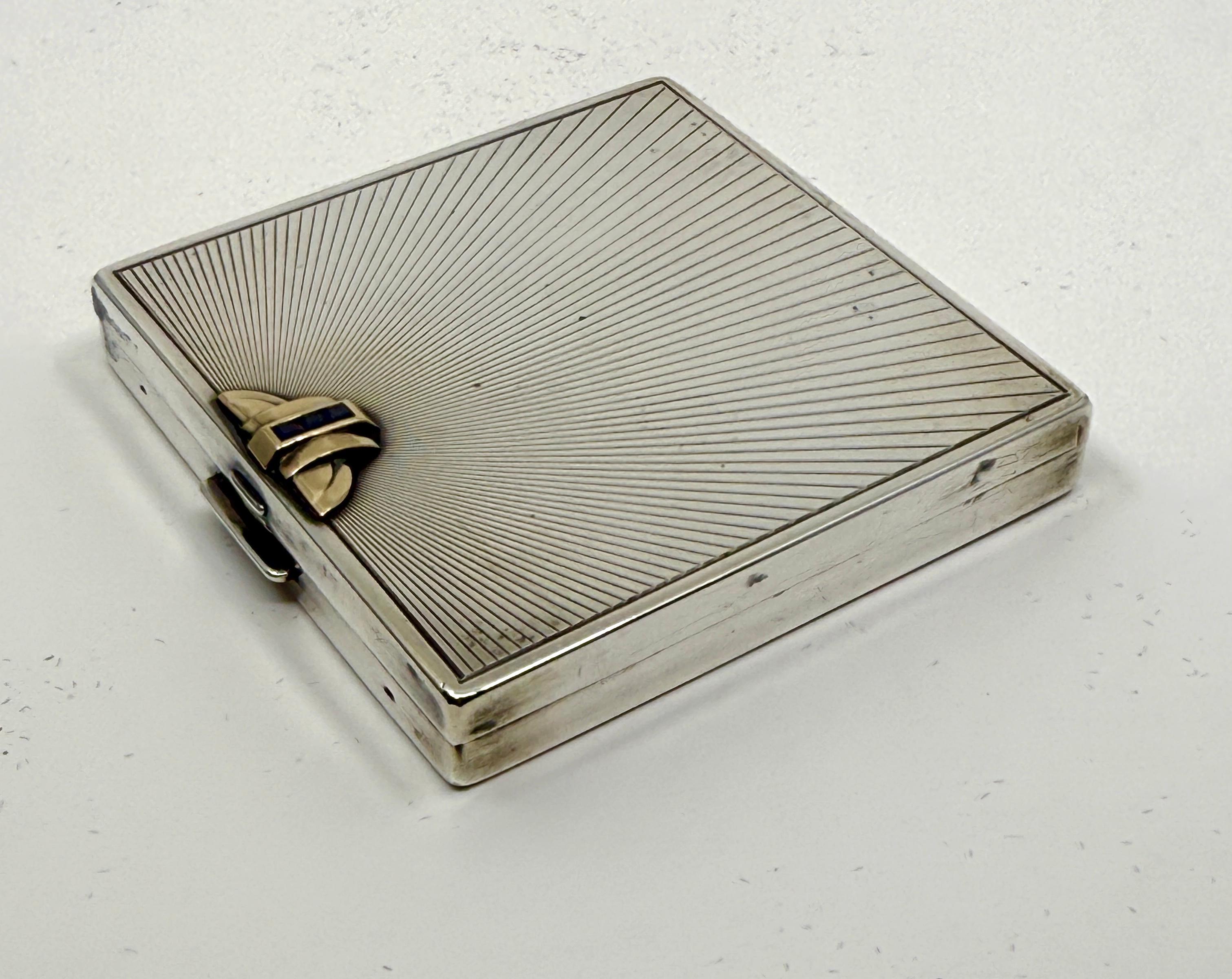 Un magnifique poudrier des années 1920 vendu au détail par Wordley, Allsopp & Bliss.  Ce compact a été vendu par diverses sociétés, de Cartier à Gorham en passant par Starr. Il est composé d'argent sterling, d'or 14k et de petits saphirs.