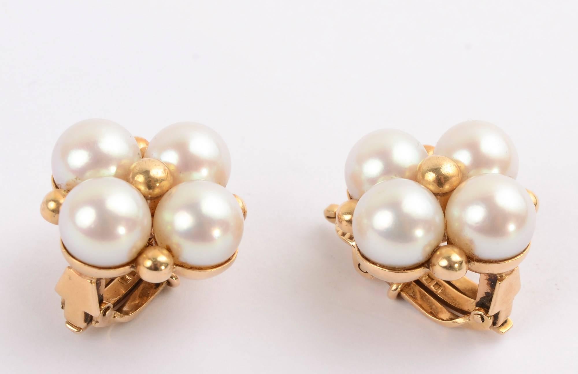 Tailored earrings by Wordley, Alsopp and Bliss of a cluster of four cultured pearls, each about 7.5 mm in size. The center and each corner has a small gold ball. The earrings measure 3/4 inch in diameter and weigh 15 grams. Clip backs can be