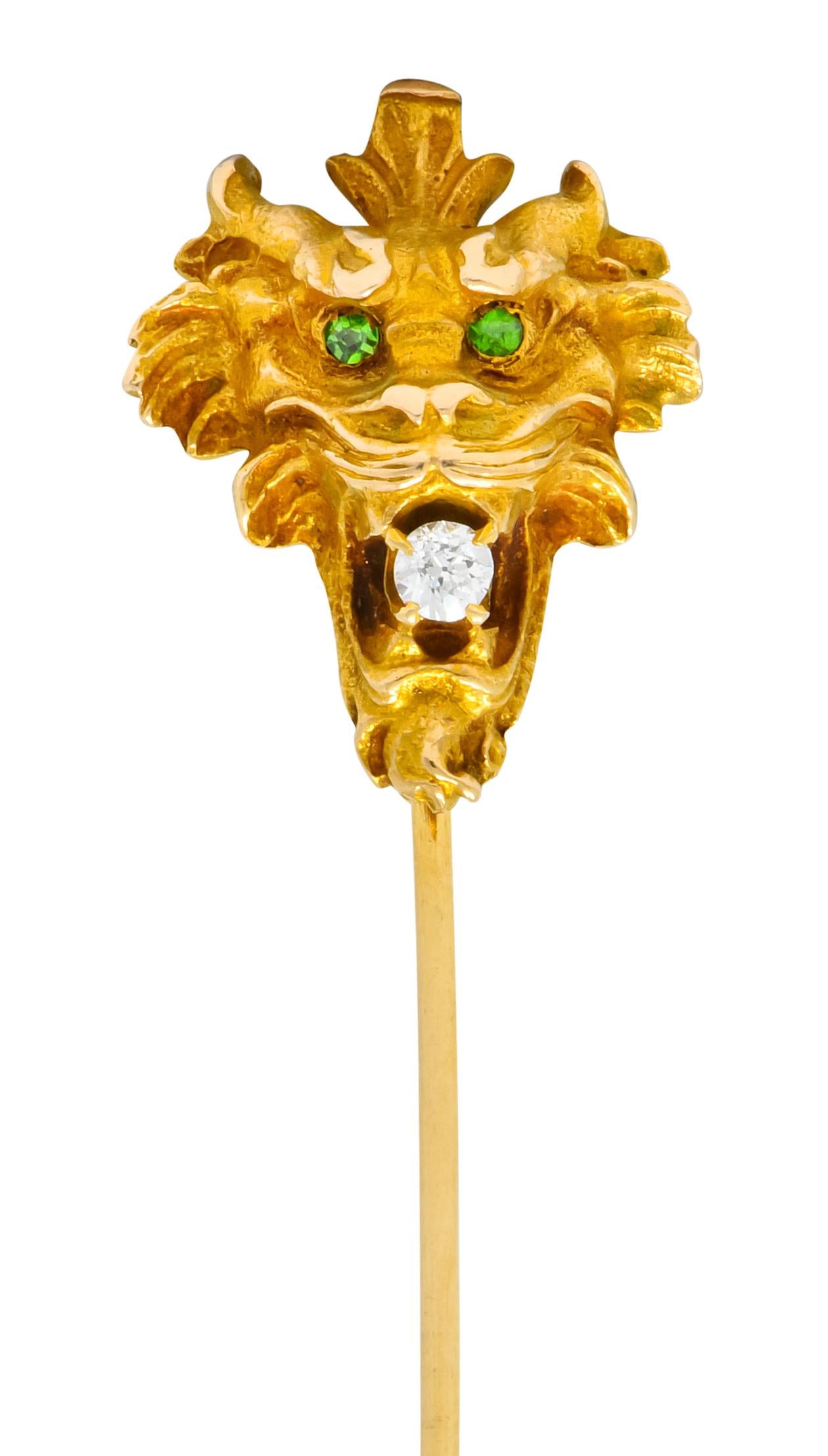 Depicting a snarling tiger face with stylized fur and a matte gold finish

Clutching in its jaws a transitional cut diamond weighing approximately 0.10 carat; eye-clean and white

Completed by two round cut demantoid garnet eyes; bright lime green