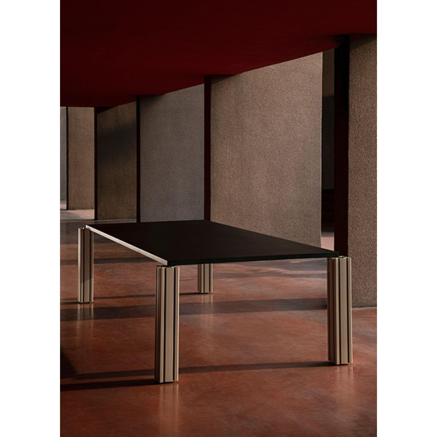 Work extruded table by Ben Gorham
Materials: Top: Antracite/Nero Ferro/Nero Rt 9822/ Peltro metal and Concrete
 Structure: Champagne extruded anodized aluminium
Dimensions: W 292 x D 132 x H 72.2 cm

Work Extruded is a table whose design is
