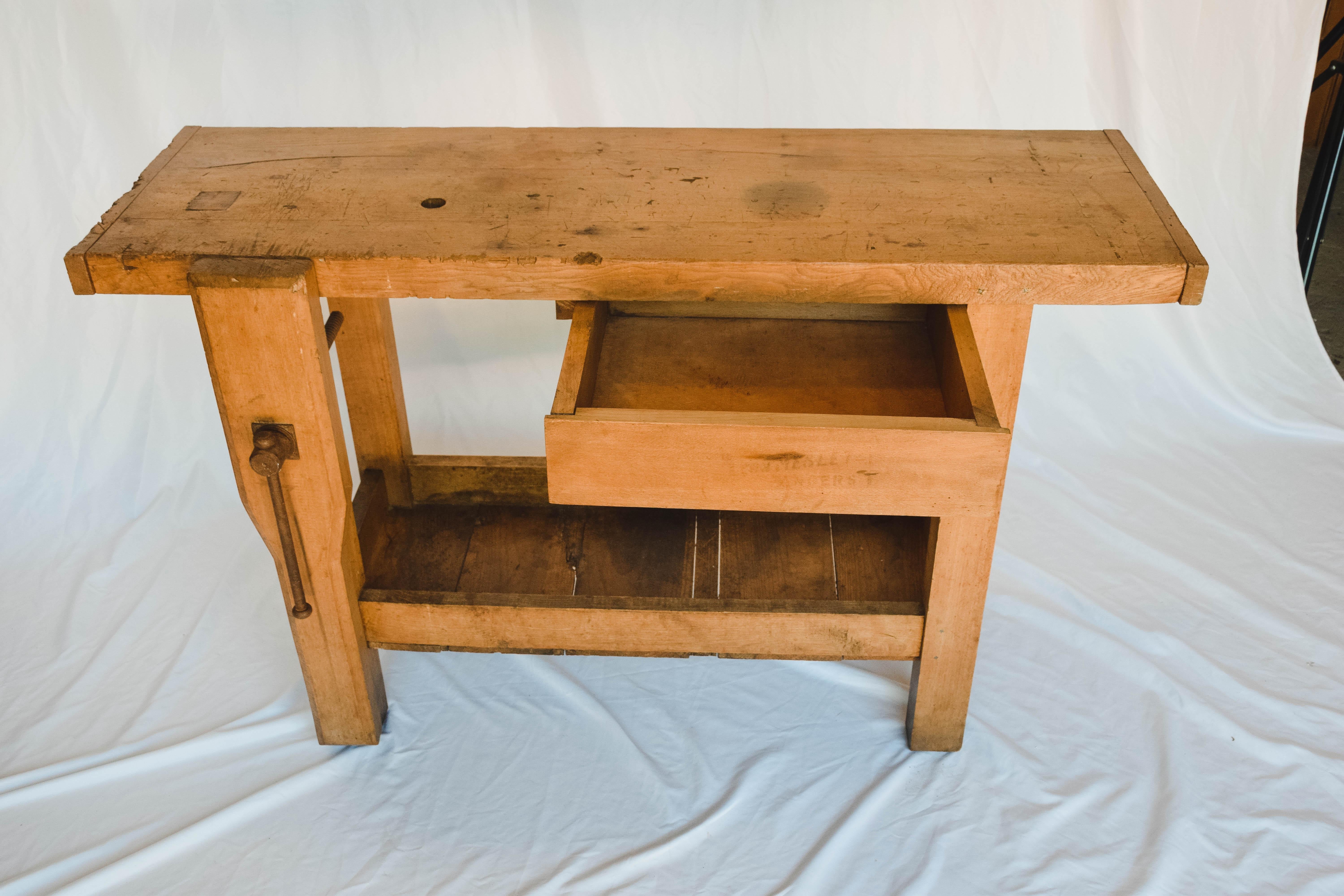 This work table provides a sturdy work space or an interesting way to display collectibles. It has a lower shelf and one drawer. At home in a workroom or a family room, this table provides form and function.