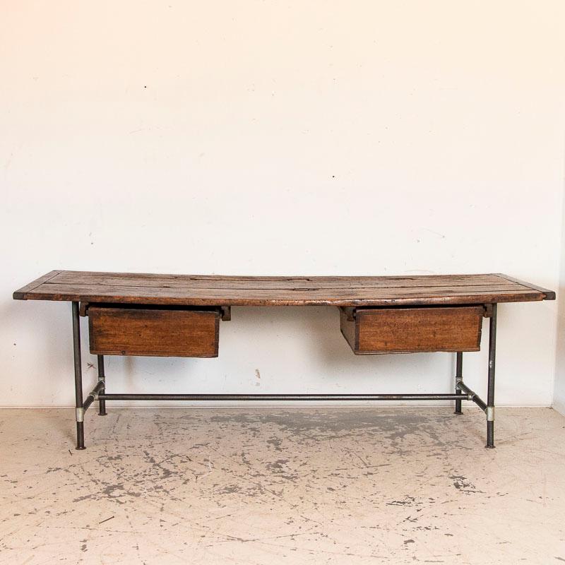 Huge, rough hewn work table loaded with character, this table makes a big impression. The deep, rich patina is thanks to many years of use reflected in the bowed top and every scratch and gouge. The planks show expected age related separation, and