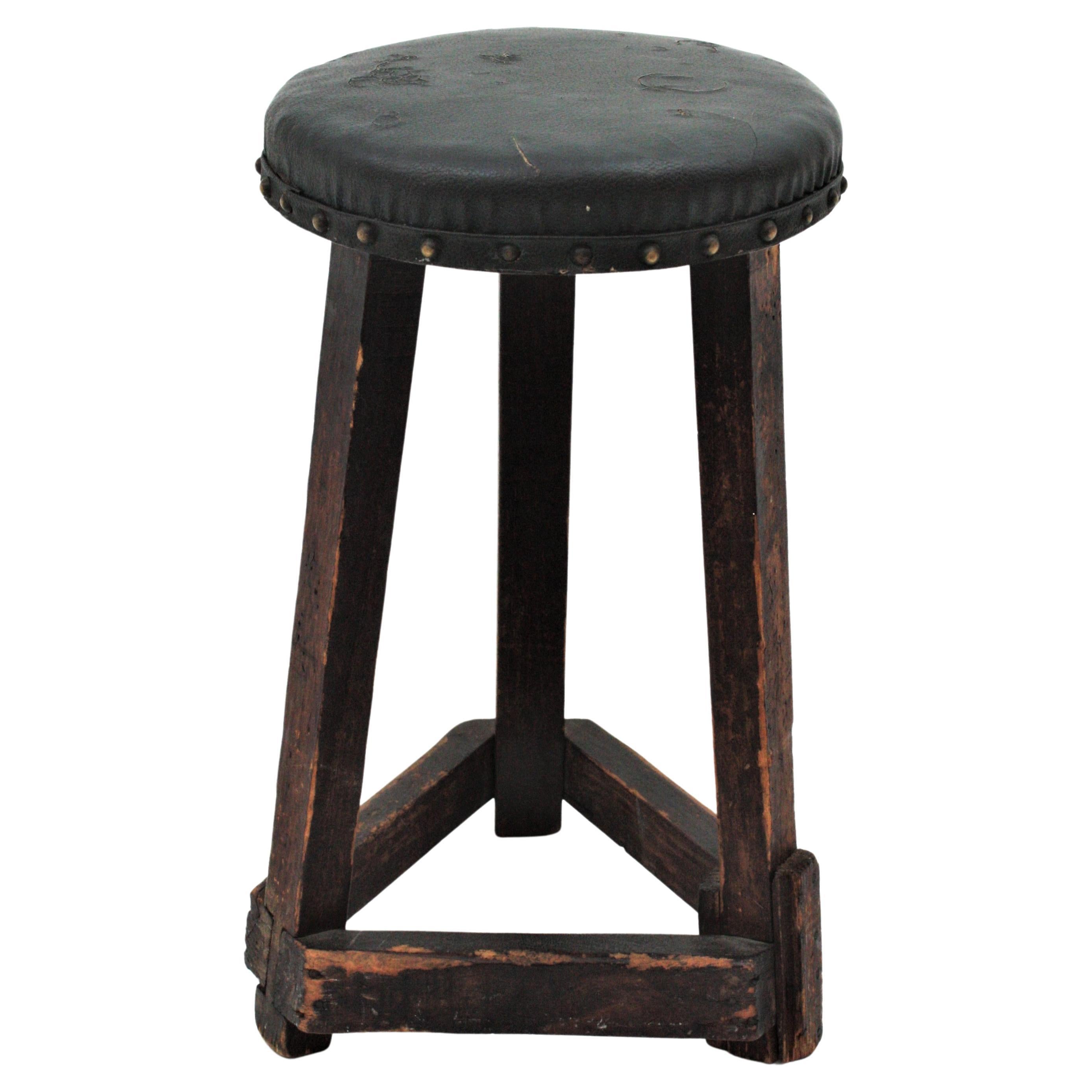 Industrial Wood stool with a three-legged base and canvas round seat. Spain, 1920s-1930s.
This workshop stool has a heavy construction, great shape and character. It has three legs with wood strecthers joining each leg. The top is upholstered in