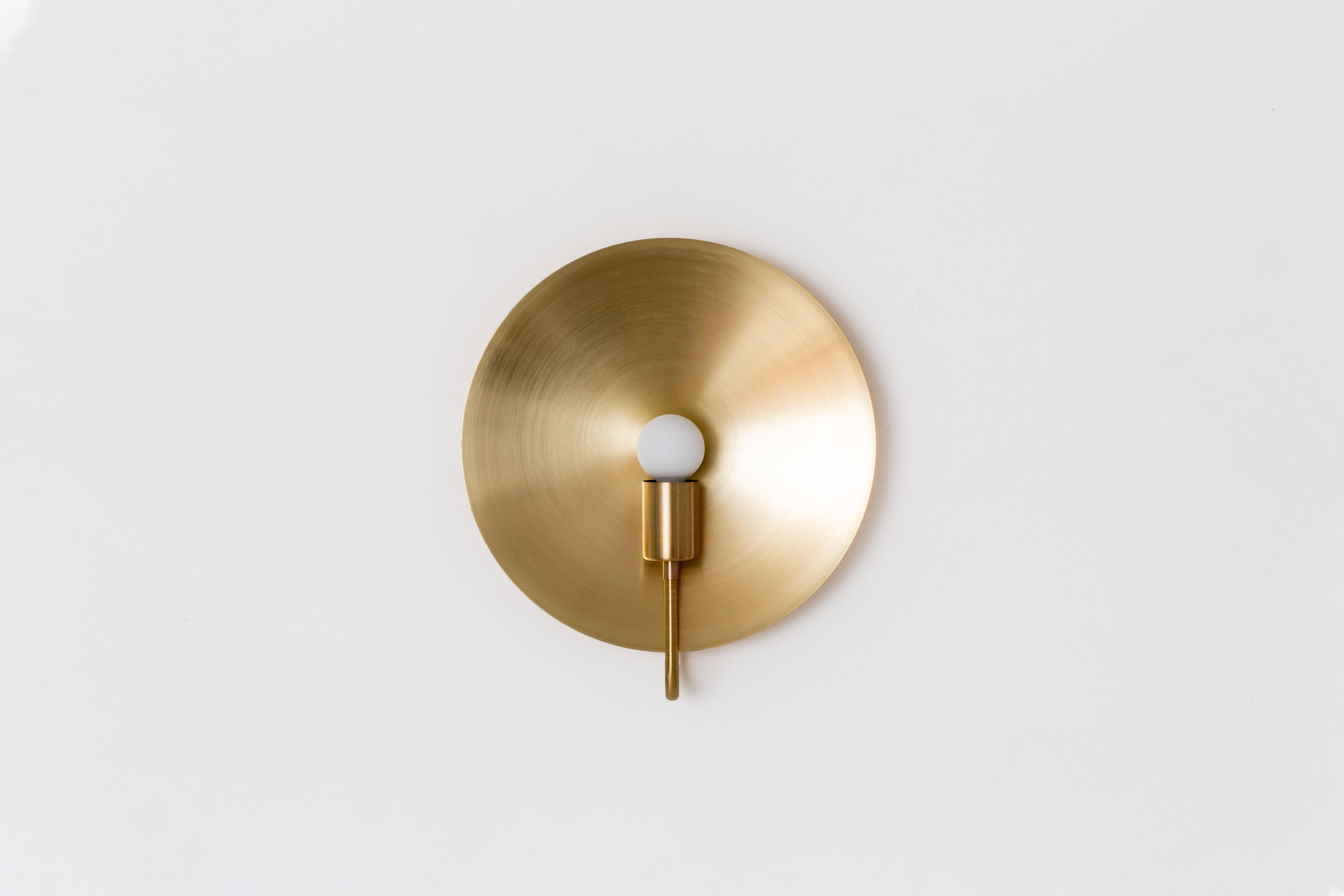 A fixed, wall-mounted version of our classic Helios table lamp, this ADA compliant fixture is a sculptural object d’art. This sconce celebrates the celestial while maintaining a minimal footprint. A monumental spun-metal disc amplifies the glow from