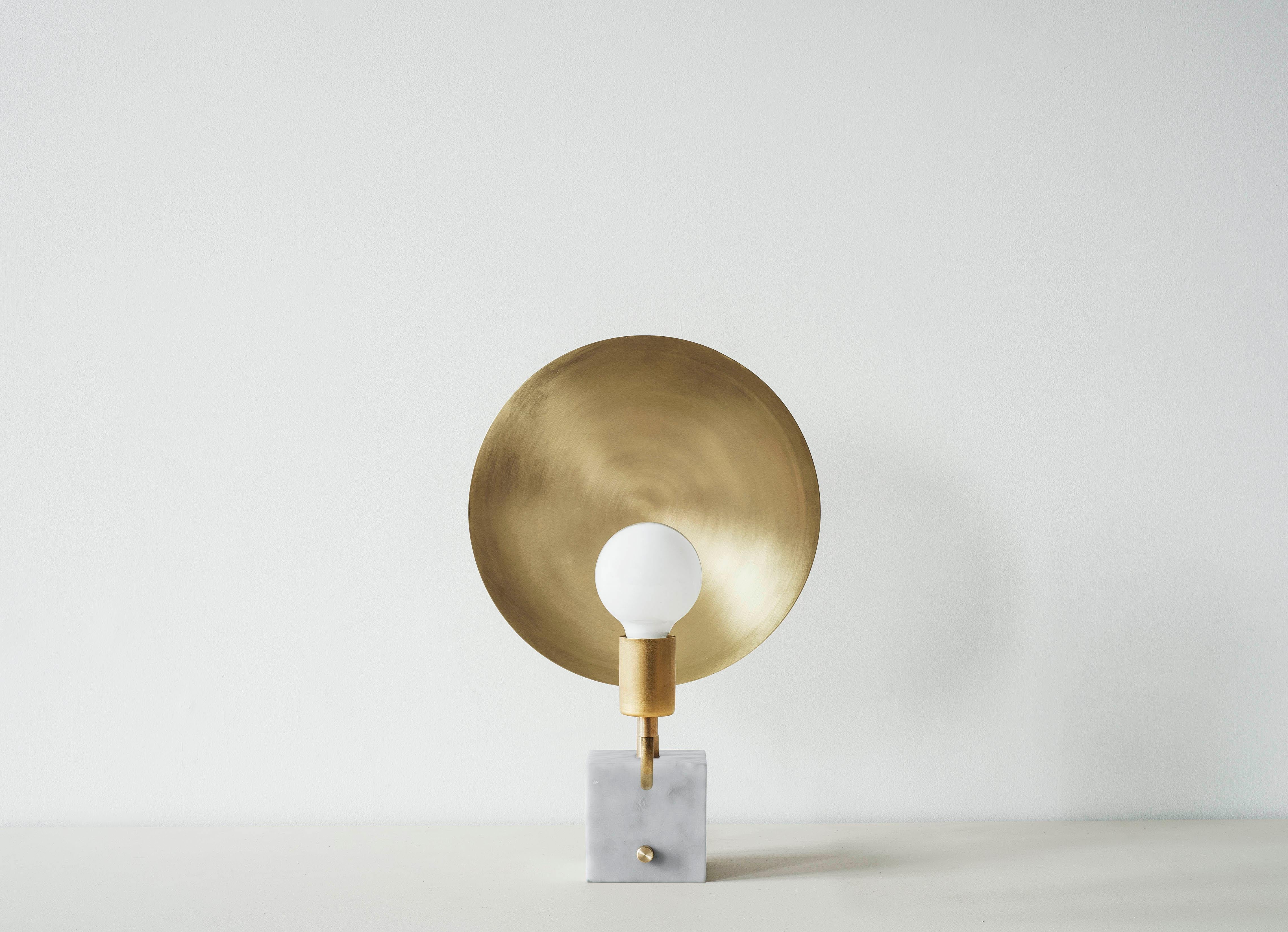 This table lamp celebrates the celestial. A single light source is positioned directly opposite a large brass dish, evoking the scale of the planets at the scale of the tabletop with infinite combinations of luminosity and orientation, the Helios