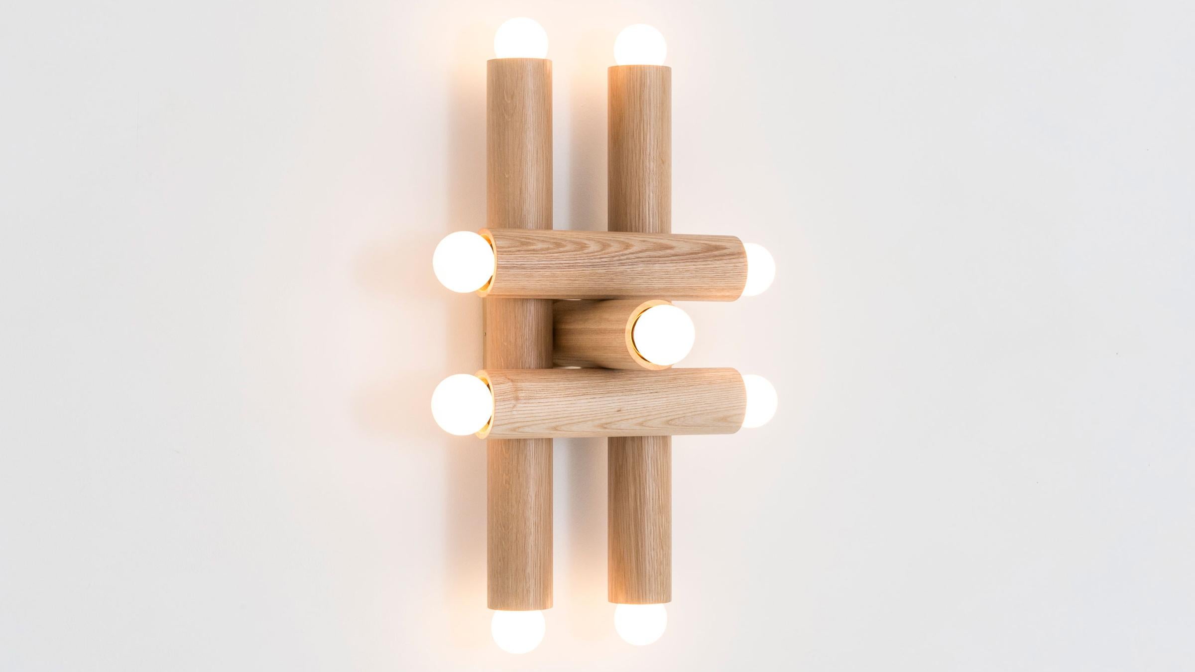The hieroglyph sconce is composed of nested wood cylinders, the foundational elements of our popular and versatile LODGE collection. The 9-bulb fixture makes a striking luminous statement, referencing essential abstract forms of the De Stijl