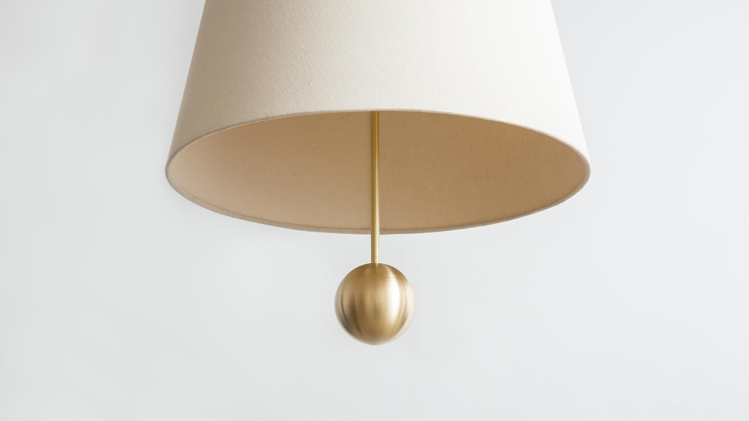 The house cord pendant large makes a bold statement via an iconic domestic form. Creating a graphic beam of light both above and below, the shade’s interior and exterior is swathed in natural linen. An oversized metal ball drops beneath the fabric