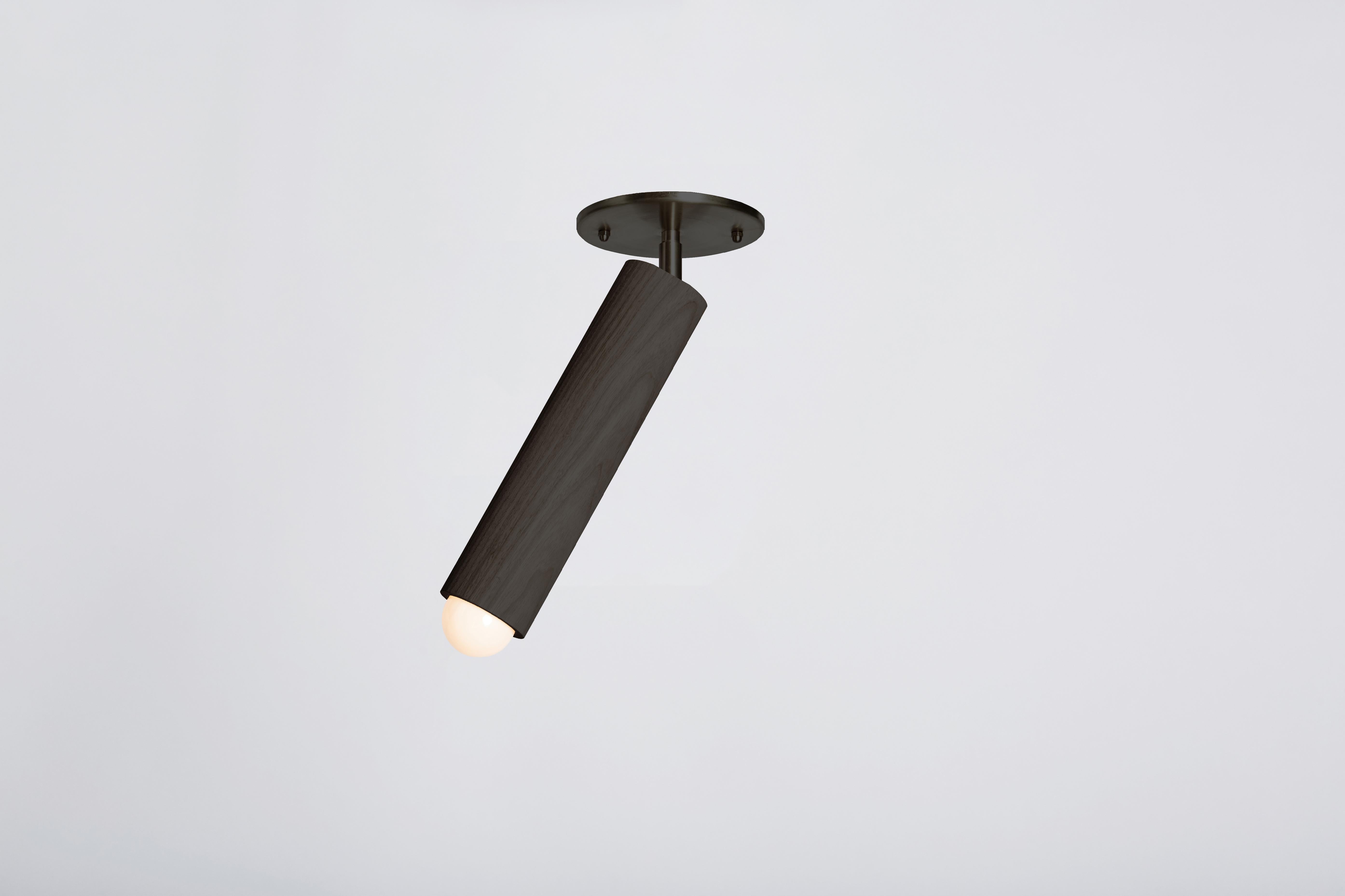 The lodge flush mount is composed of a singular wooden column suspended from a metal canopy. The fixture swivels from side to side, directing light from a softly glowing bulb. Made in the USA, UL listed.
 