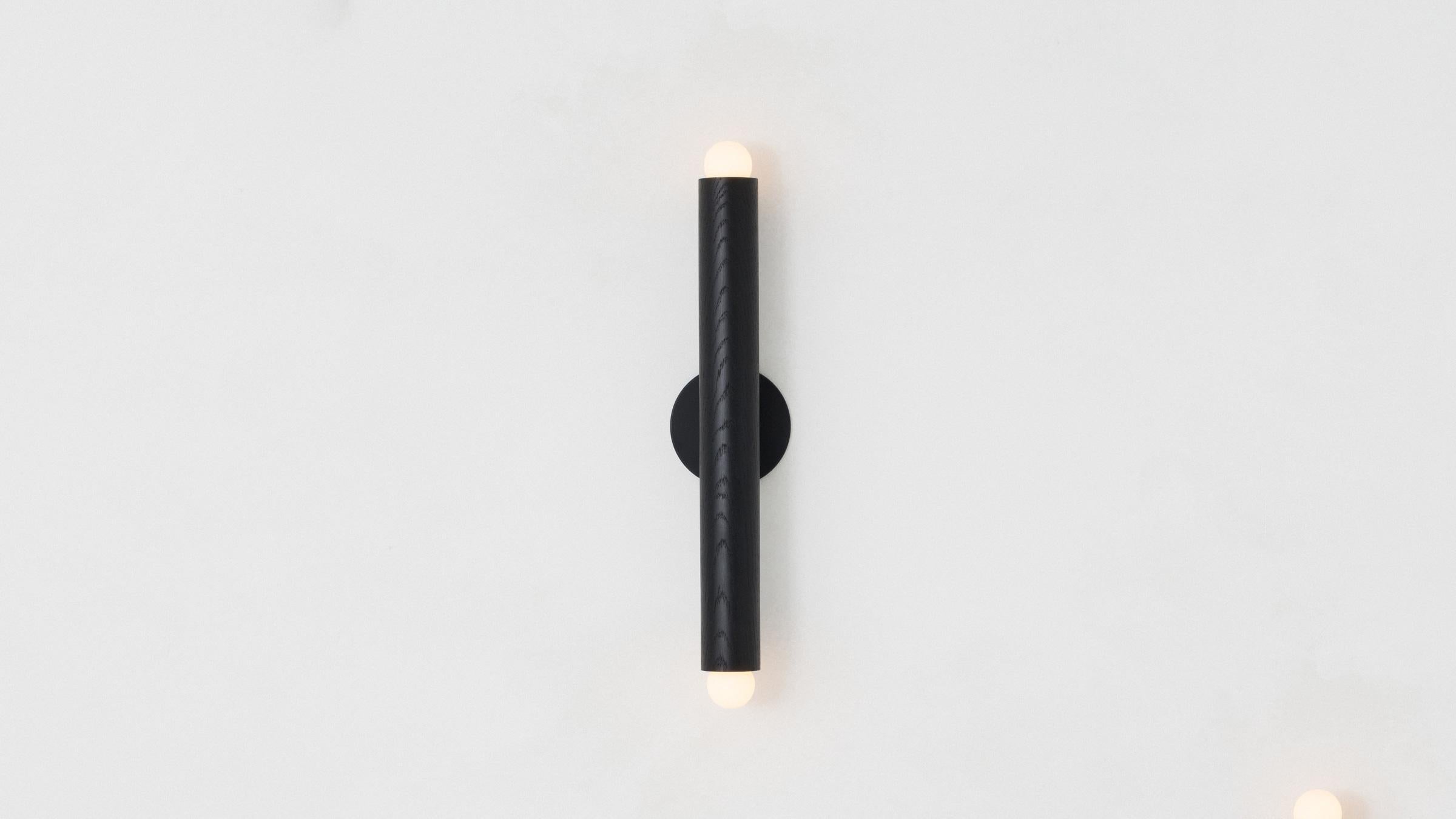 The lodge linear sconce is an elongated vertical gesture capped at each end by a porcelain LED bulb. A lithe but powerful presence makes this fixture ideal for use in a vanity or hallway. Made in the USA. UL listed. Damp rated upon request.