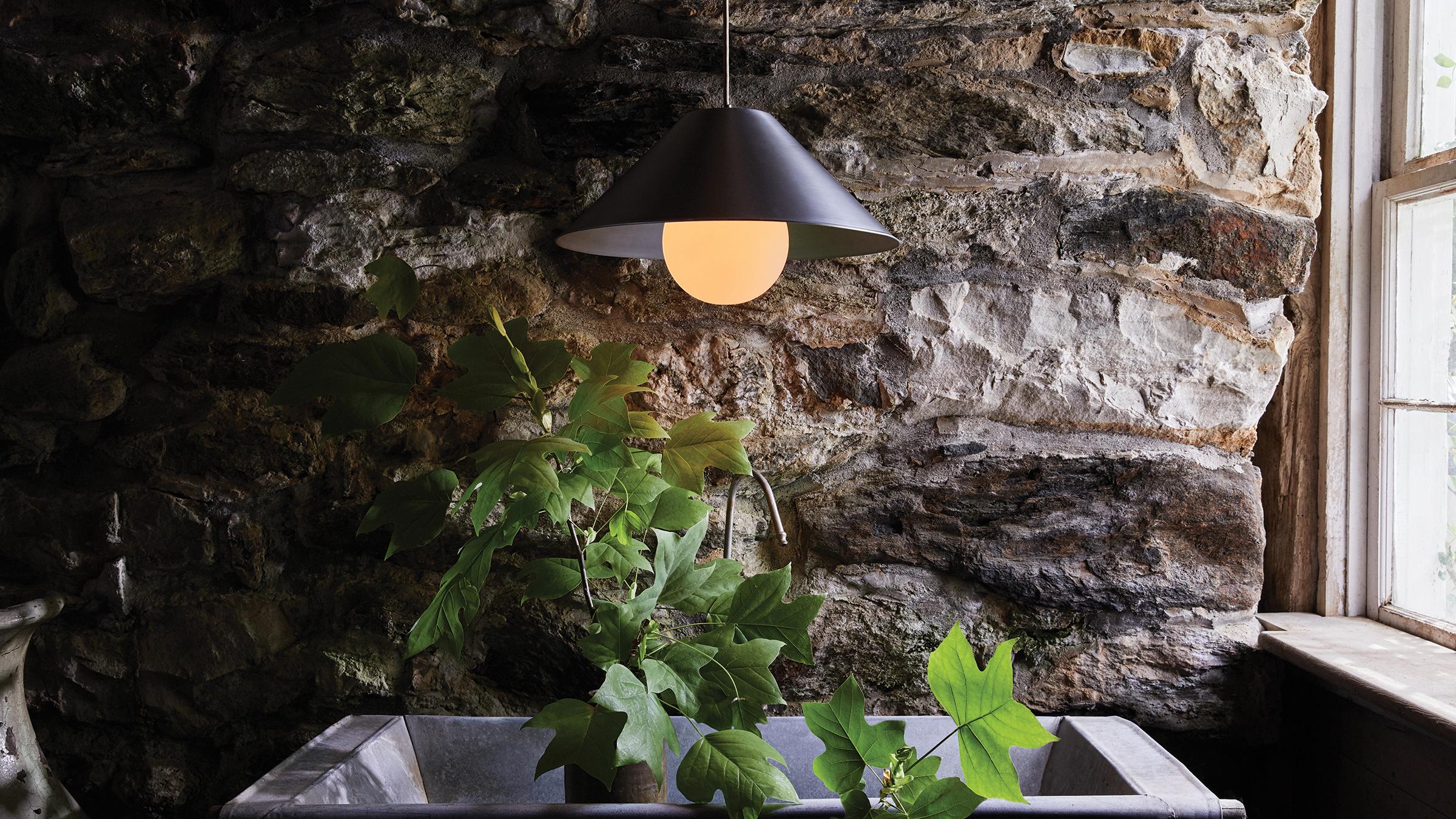 Monumental pendant small presents cool and softly reflective waxed aluminum at an intimate scale. When illuminated this elemental form transforms into a world of warm contours and optical topographies. Suspended by a delicate cloth cord this fixture