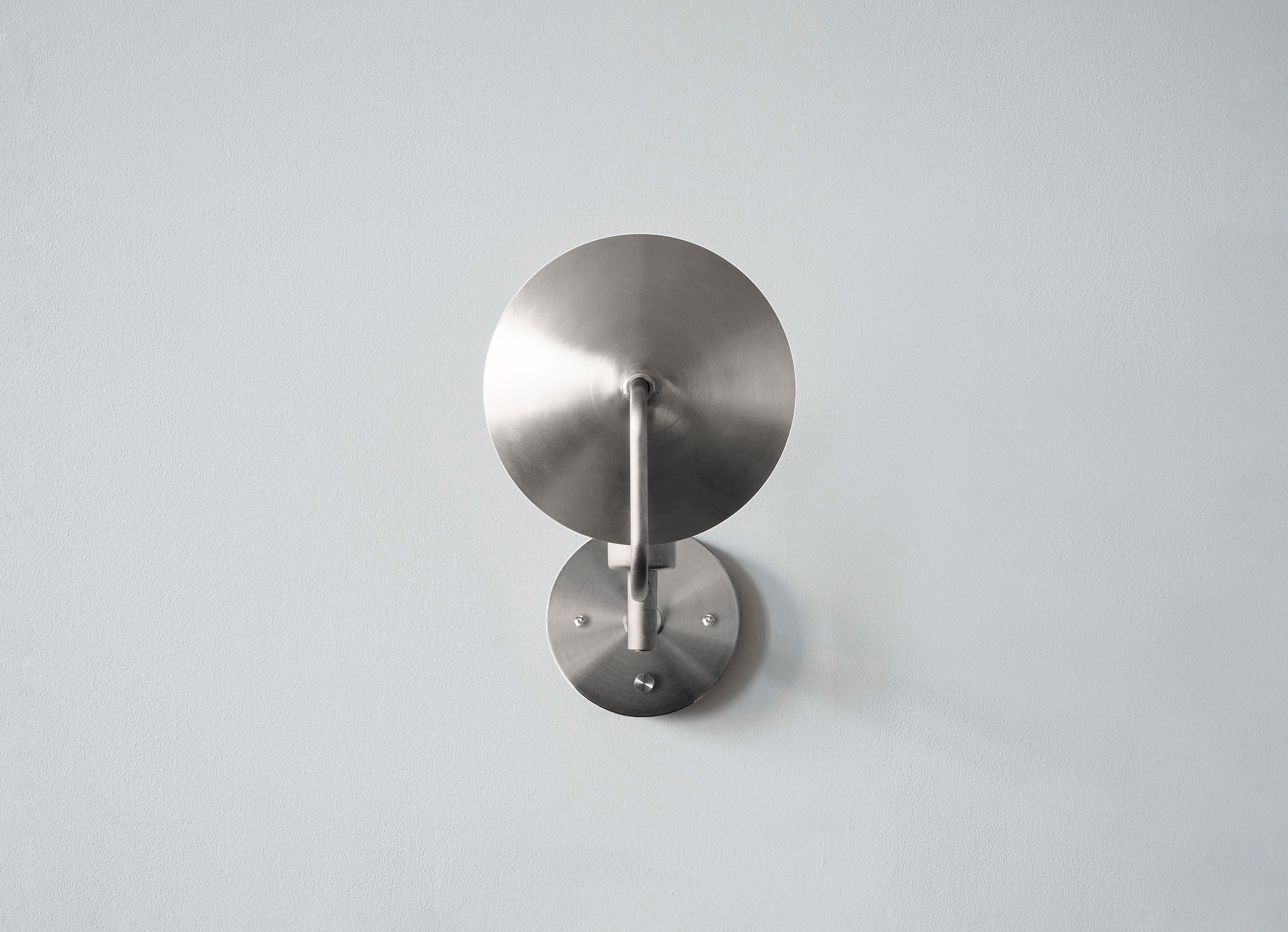 The orbit sconce is a modern interpretation of an early American candle form with a reflective spun brass disc rotating 320 degrees, the sconce can act as both a reflector and deflector of light. The most elemental piece of the Orbit series, the