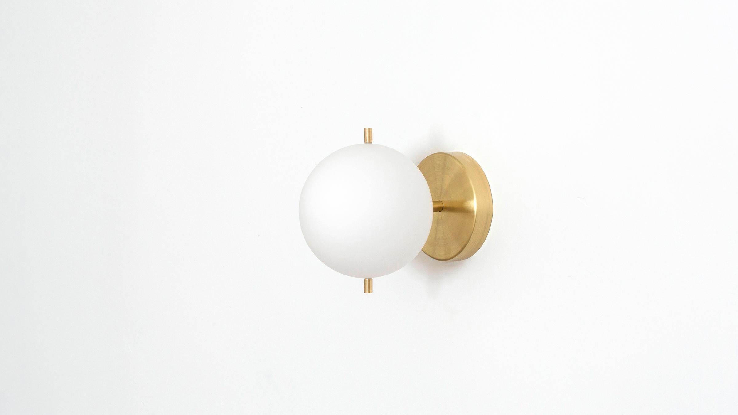 Signal Solo is our most streamlined addition to the Signal collection, featuring a single hand blown glass globe that floats delicately off the wall or ceiling via a small brass post, held in place by a pair of metal pins. Available in Hewn Brass,
