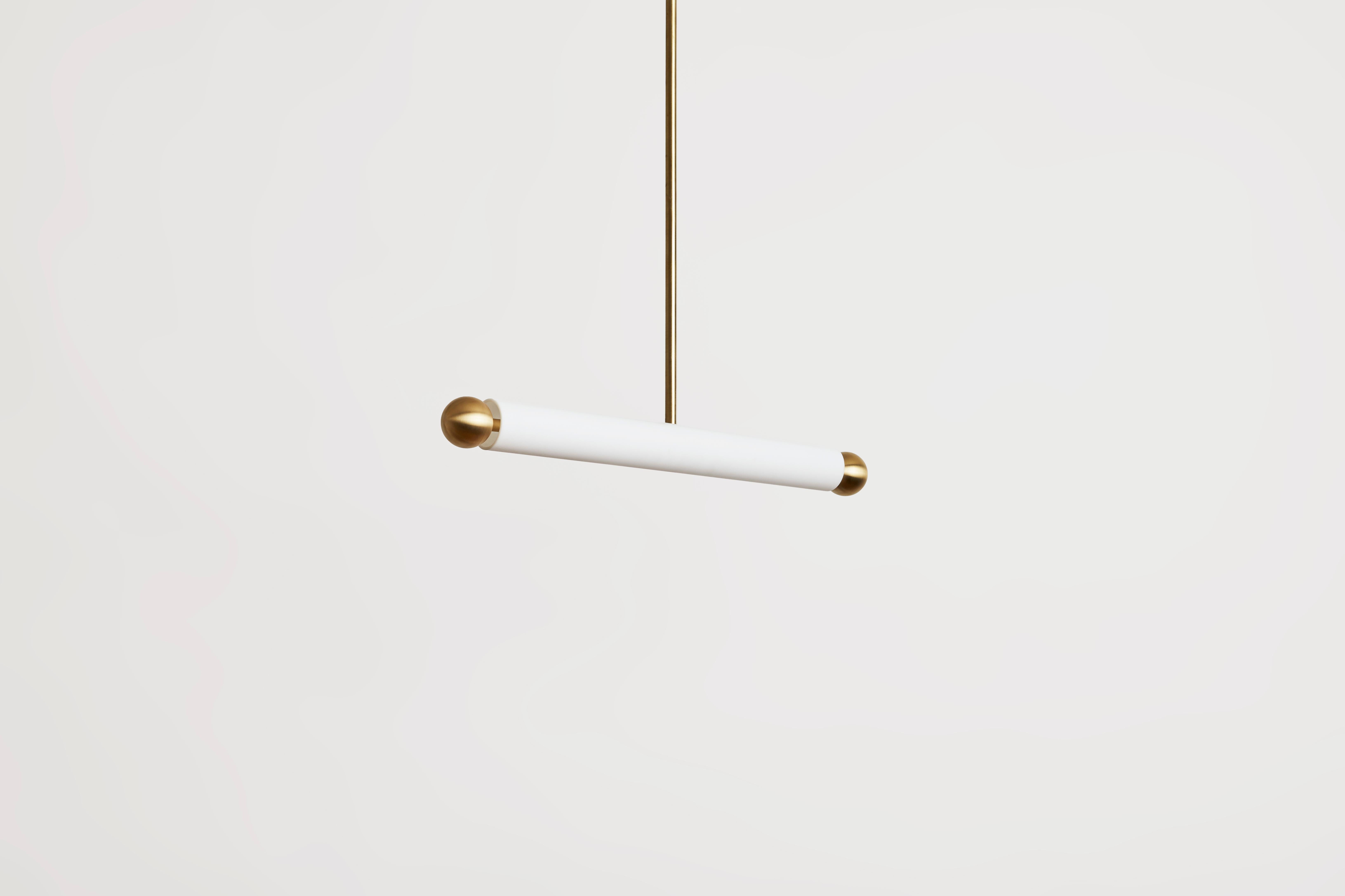 La suspension TUBE diffuse un faisceau lumineux audacieux dans l'espace, flottant délicatement au-dessus d'un comptoir, d'une table ou d'un hall d'entrée. Le verre soufflé mat est contrebalancé de manière ludique par deux boules de métal, présentant