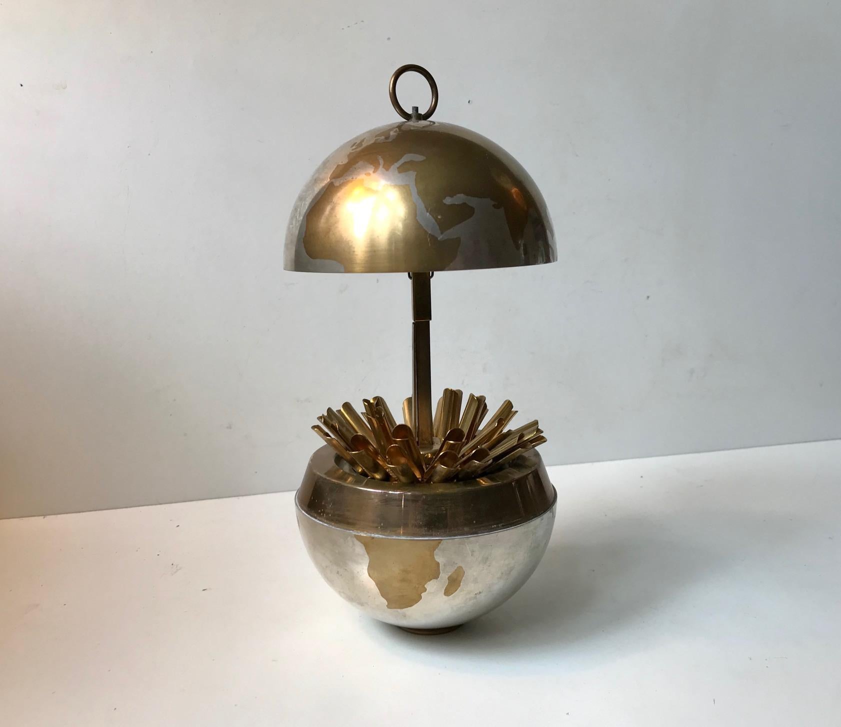 Authentic world globe cigarette dispenser popularized in Germany during the 1930s. This example is also German and dates from the 1950s. It can contain 25 cigarettes that spreads out almost like a flower when opened. The interior mechanism is tight