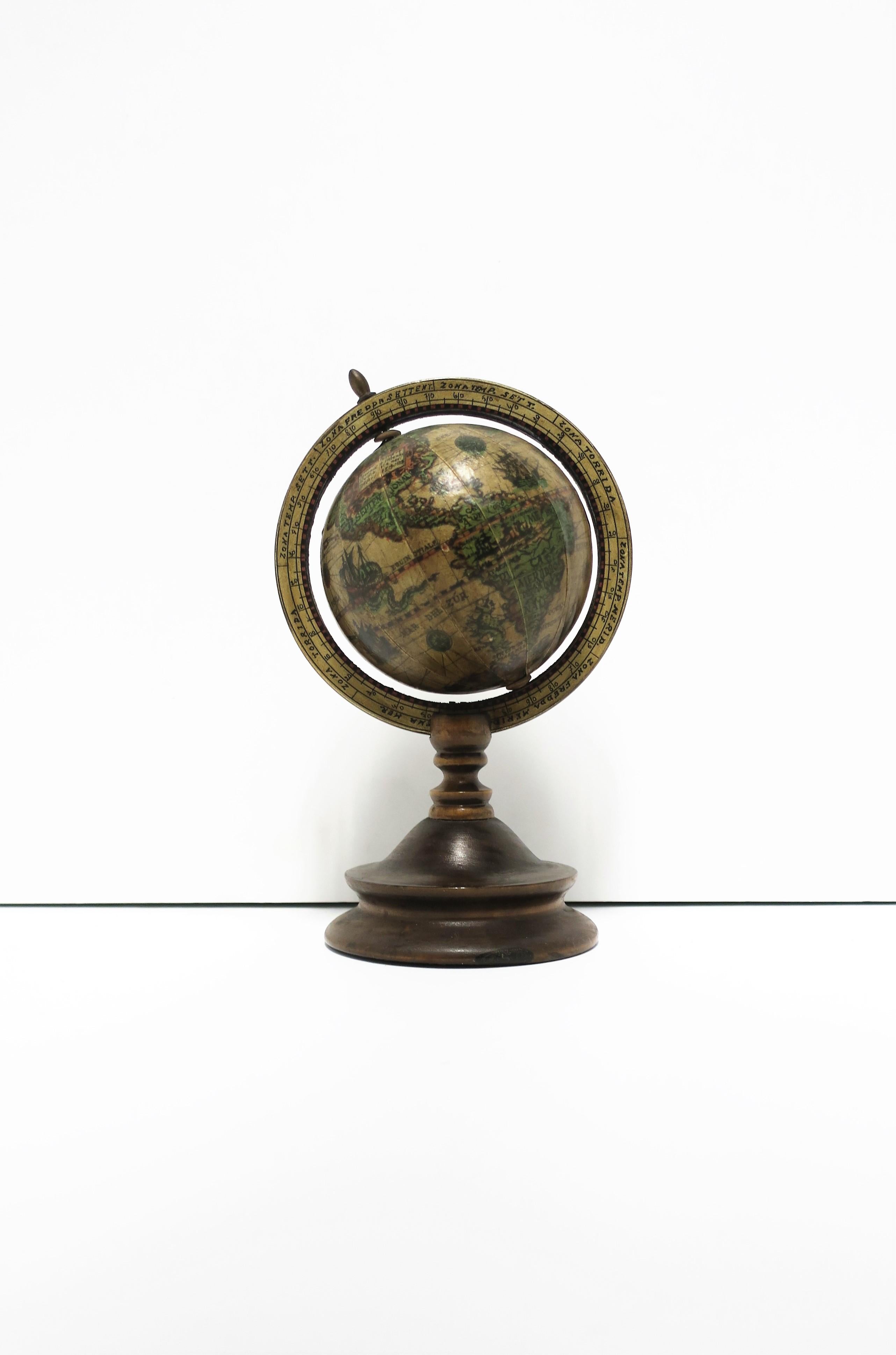 An Italian world globe that spins, circa mid-20th century, Italy. A world globe of wood and brass details. A great decorative object for a bookshelf, étagère, desk, office, library, etc. Dimensions: 9.5