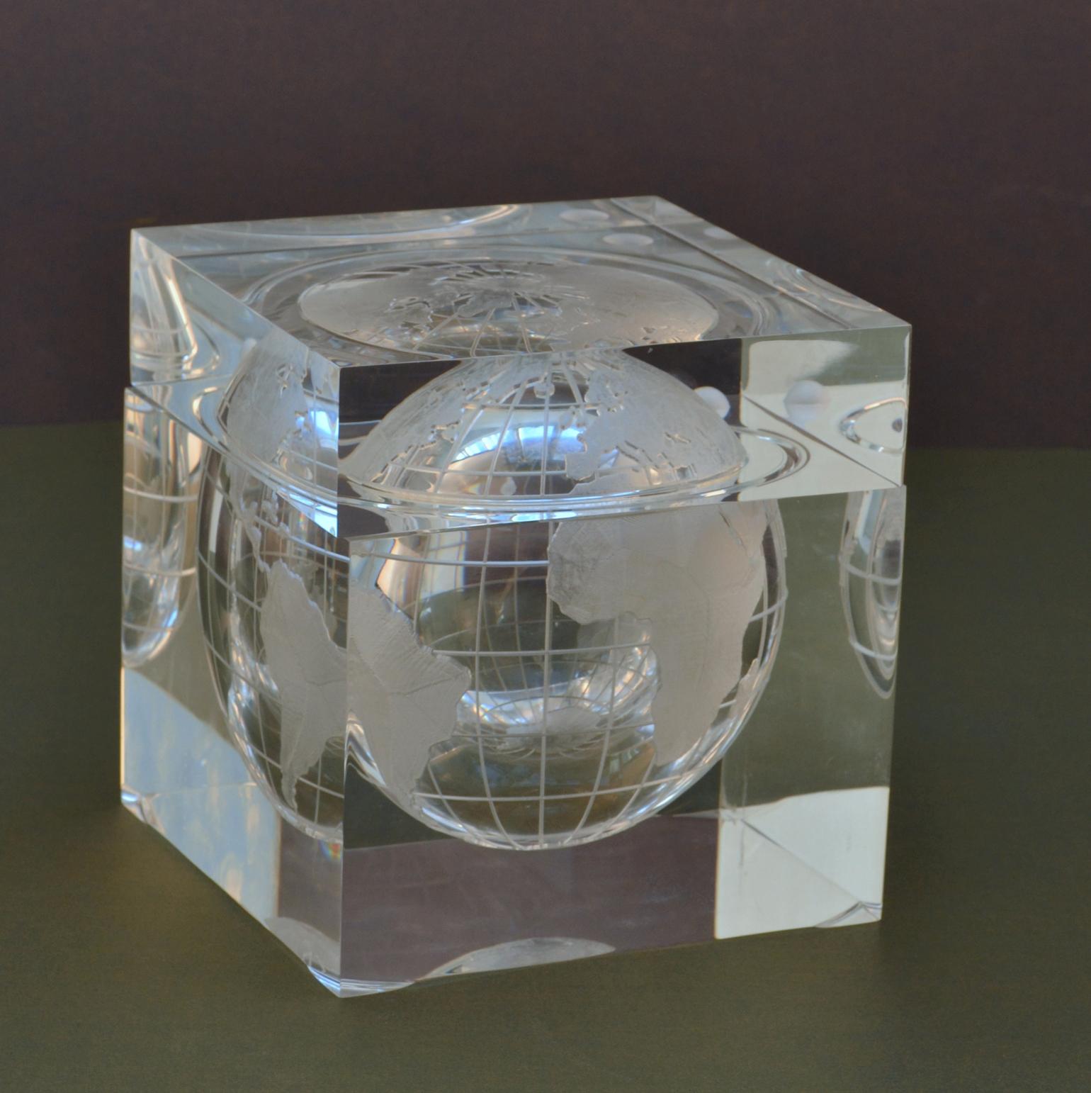 Lucite cube bar ware depicting the world captured in a cube of acrylic that resembles an ice cube. Frosted world map of continents and orbiting moon. Suspended world globe ice bucket is designed and created by Alessandro Albrizzi, Italy 1960's. The