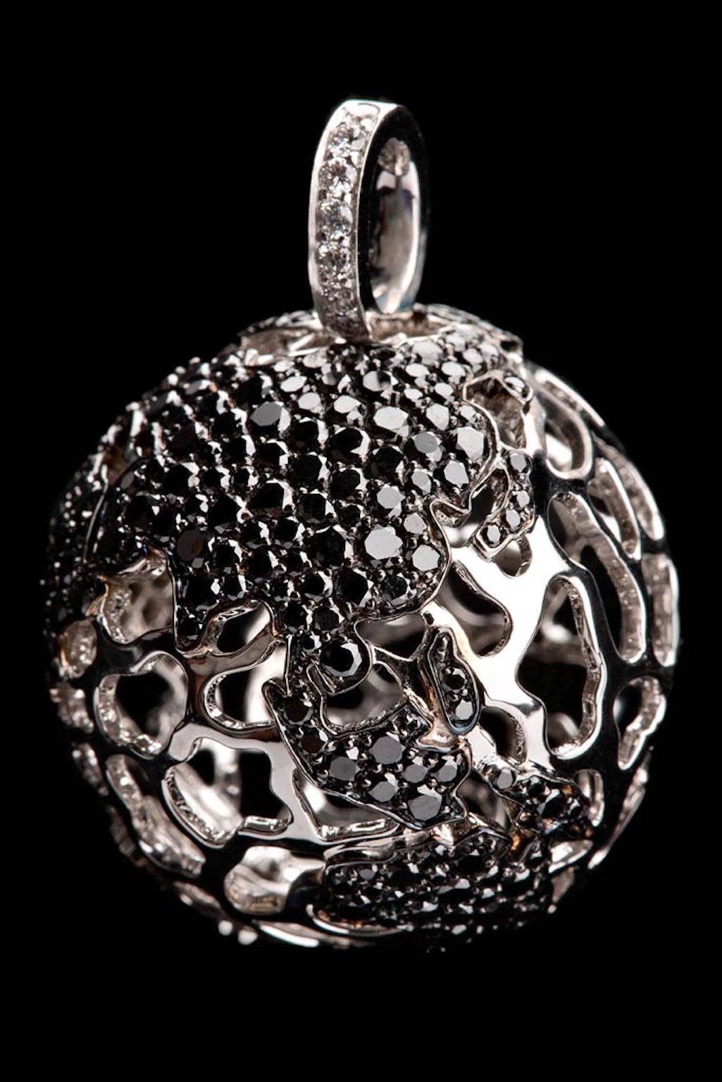 Impressive world globe pendant in white 18 carat gold with black diamond continents and one white diamond over Dallas, Tx.