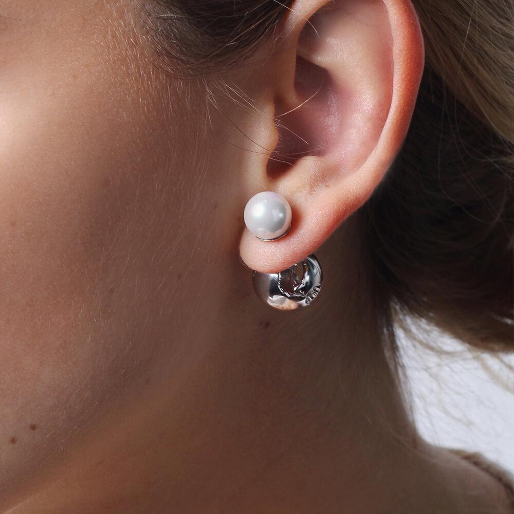 The Globe Pearl Earrings feature a double view design — a gorgeous globe with cut out world map details and a contrasting natural shell pearl that can be seen on the front of the ear.  This pair effortlessly complements any stylish and chic