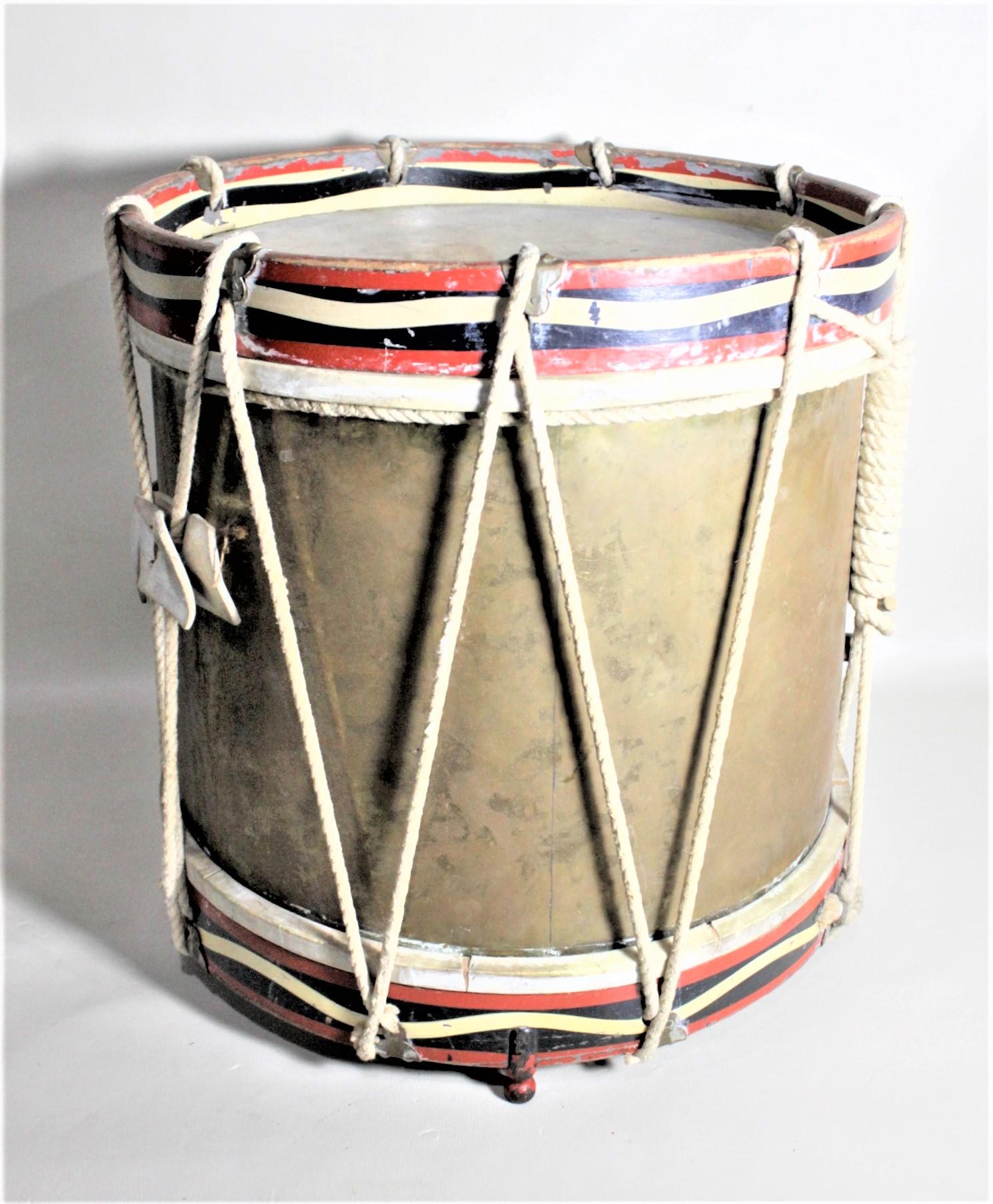 This interesting brass and metal marching band drum was made by the A.F Mathews & Co. of France in 1941 in a French Regimental style. The body of the drum is composed of brass and either rim is solid steel. The top and bottom are lashed together