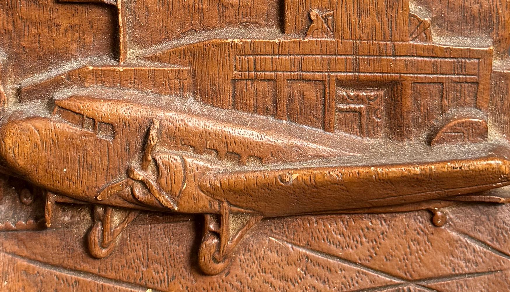 Rare and boldly designed, this World War II-era bookend depicts, in high relief, a propellor airplane in the foreground and an airport radar tower behind, all executed in plaster or composite given a faux-mahogany finish.  At the bottom of the