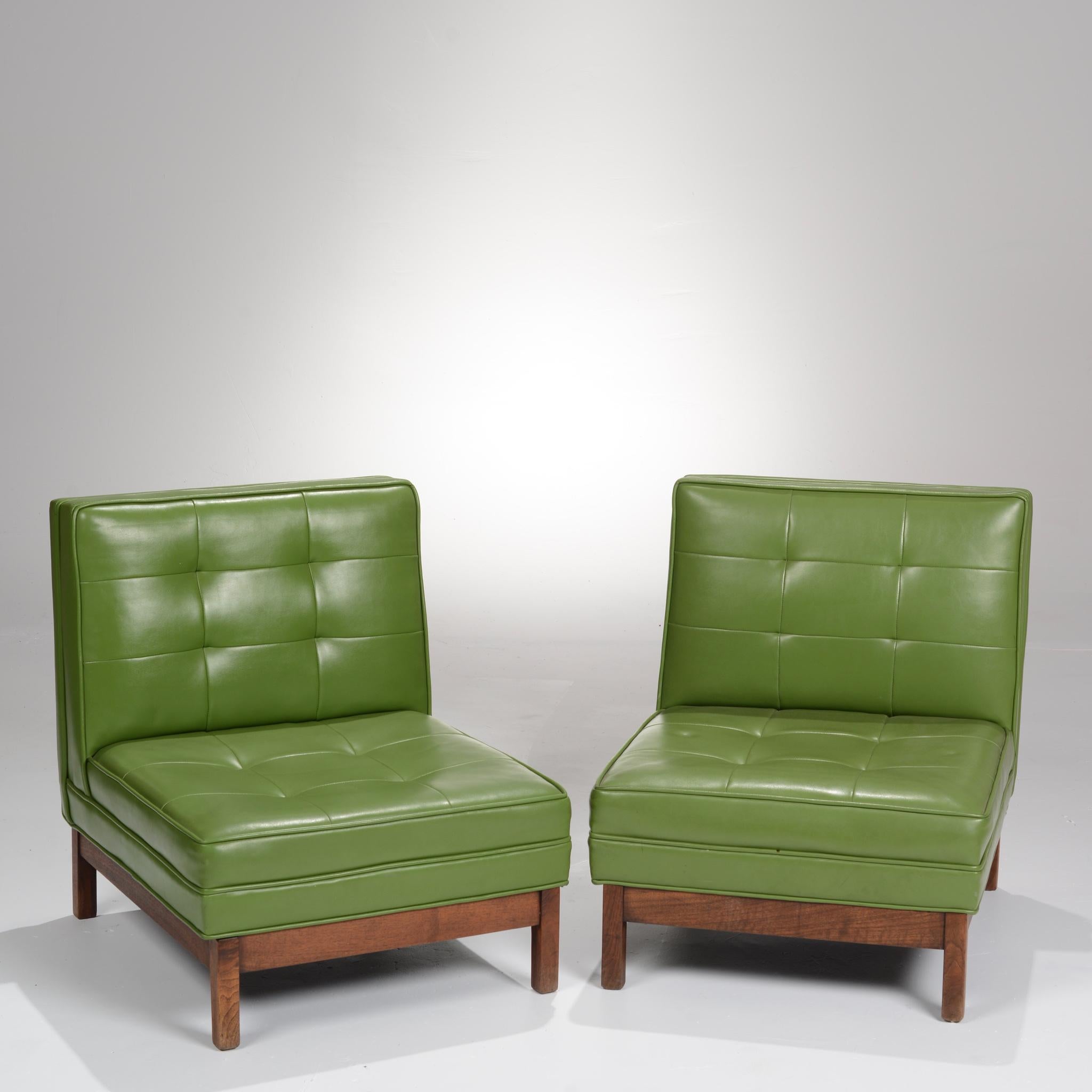 Pair of green vinyl and walnut slipper chairs in the style of Edward Wormley. These chairs are on display in our Los Angeles Arts District showroom, open 5 days a week.
 