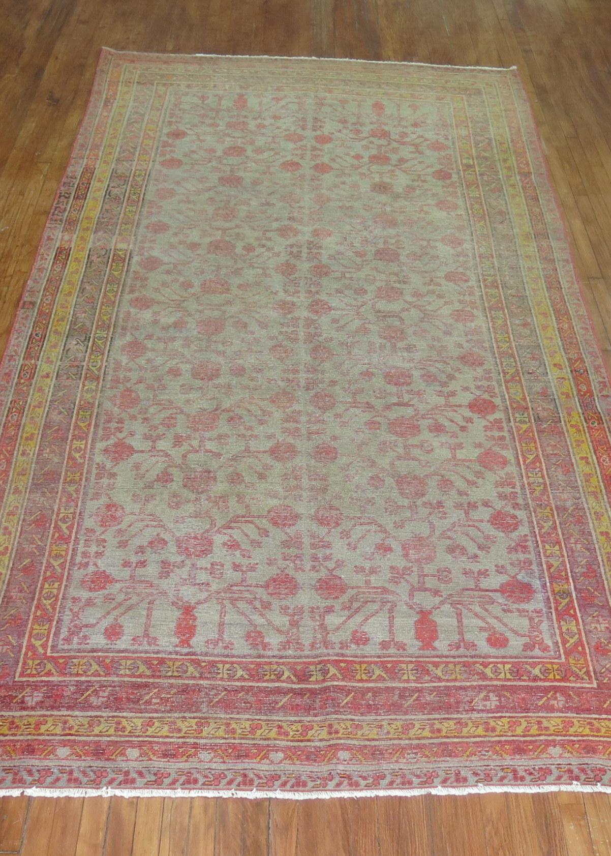 A worn early 20th century Khotan gallery rug. Gray ground, soft red accent pomegranates throughout. accents in yellow and brown

circa 1910, measures: 6'4