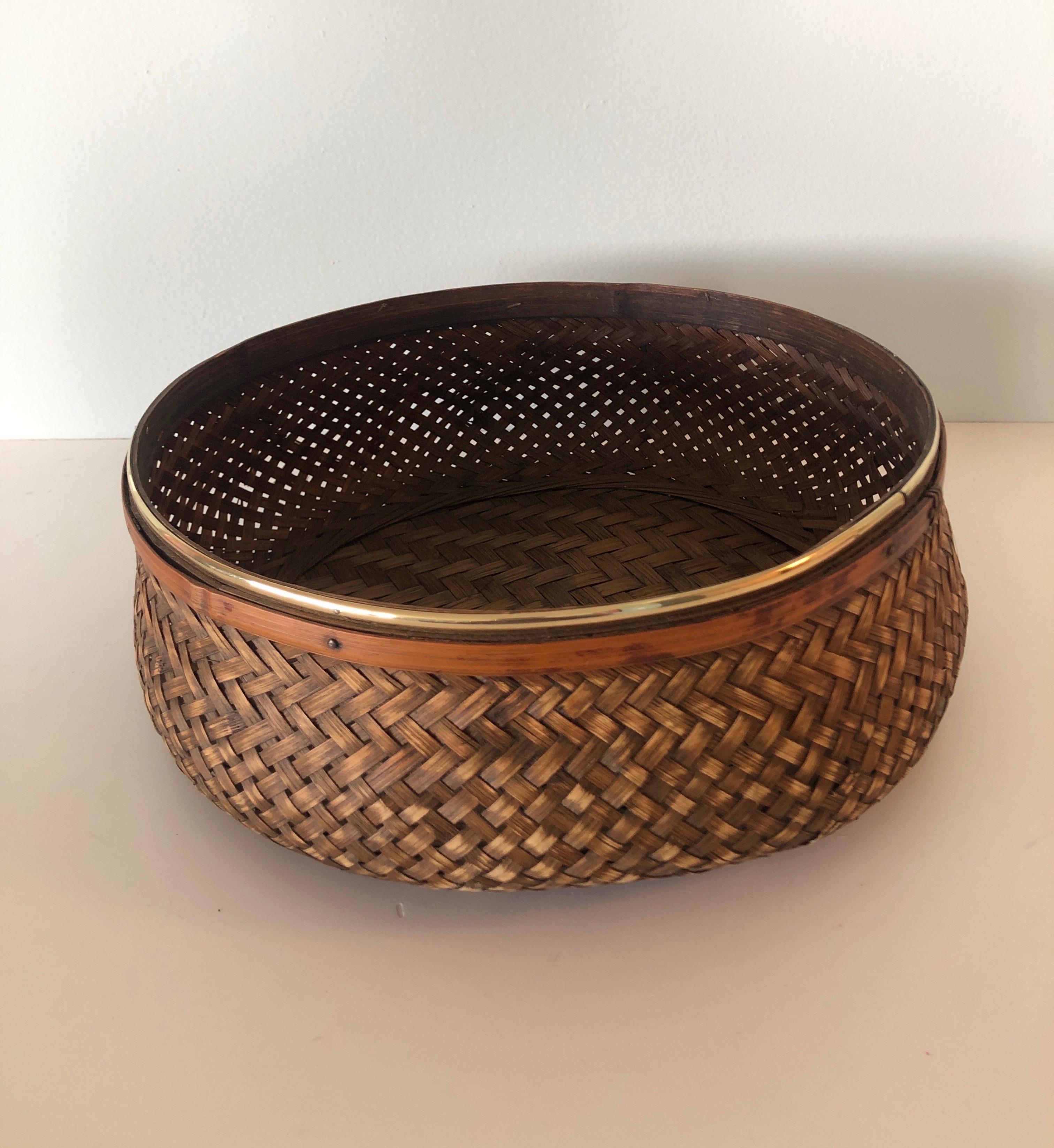 Woven Asian round serving basket, The small brass detail
is plastic not real brass.
Size: 11 x 11 x 4.75