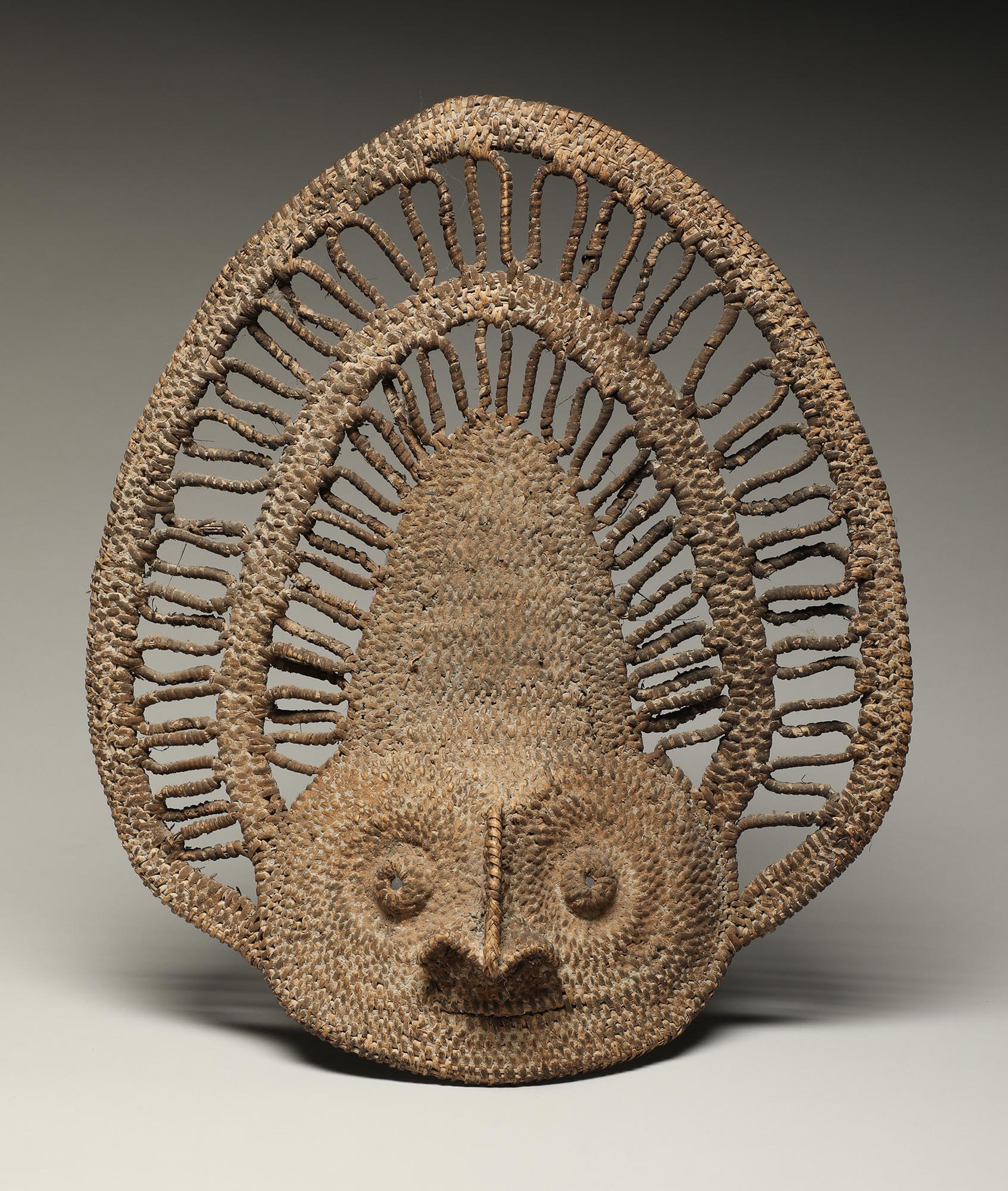 Woven basketry yam helmet mask from Papua New Guinea. Flat form with projecting nose and eyes, encrusted surface. 
13 inches high, mid 20th century. Will look great on the wall!